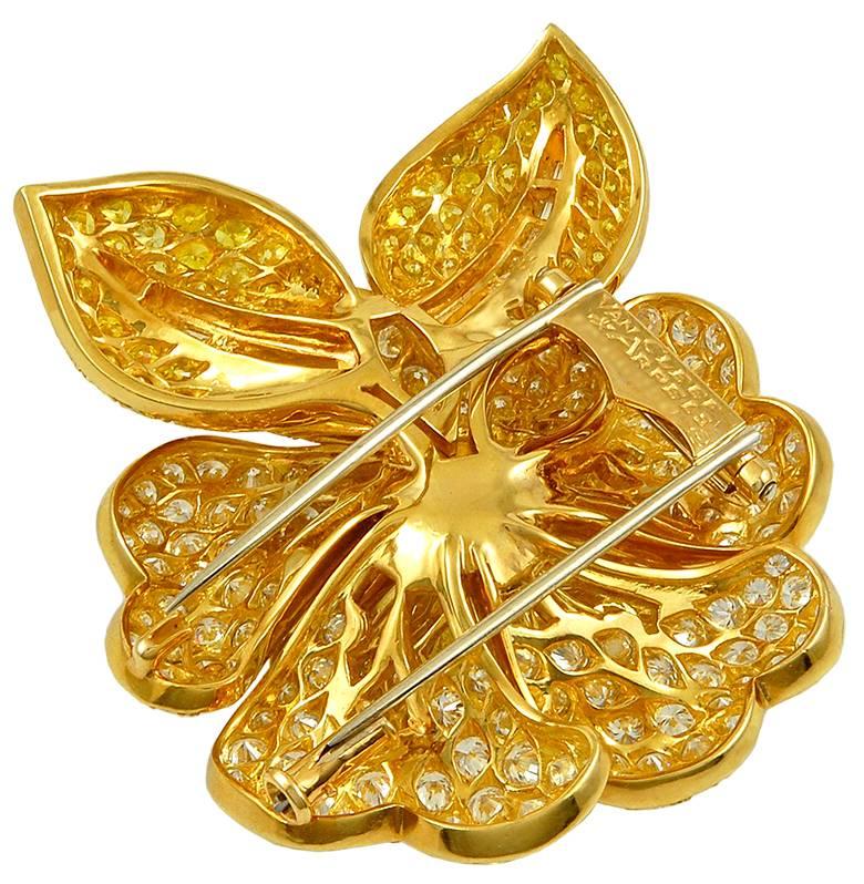 Van Cleef & Arpels Vintage 1980s  White And Yellow Diamond Gold Camelia  Brooch
A 1980's Van Cleef & Arpels diamond and fancy-colored canary yellow diamond brooch, designed as a brilliant-cut diamond Camelia flower blossom, centering upon a vivid