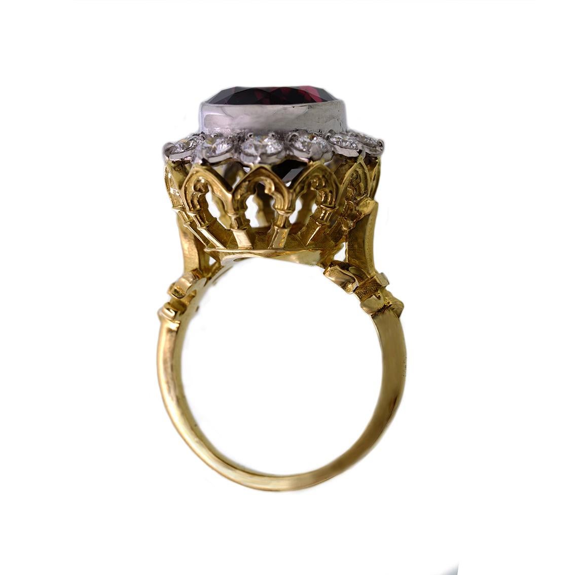 This divine ring is titled The Infinite Rapture ring and is one of a kind. Handmade in 18kt yellow and white gold this glorious ring features a central, deep red garnet approximately 11ct in weight. A halo of 12 diamonds surround the garnet weighing
