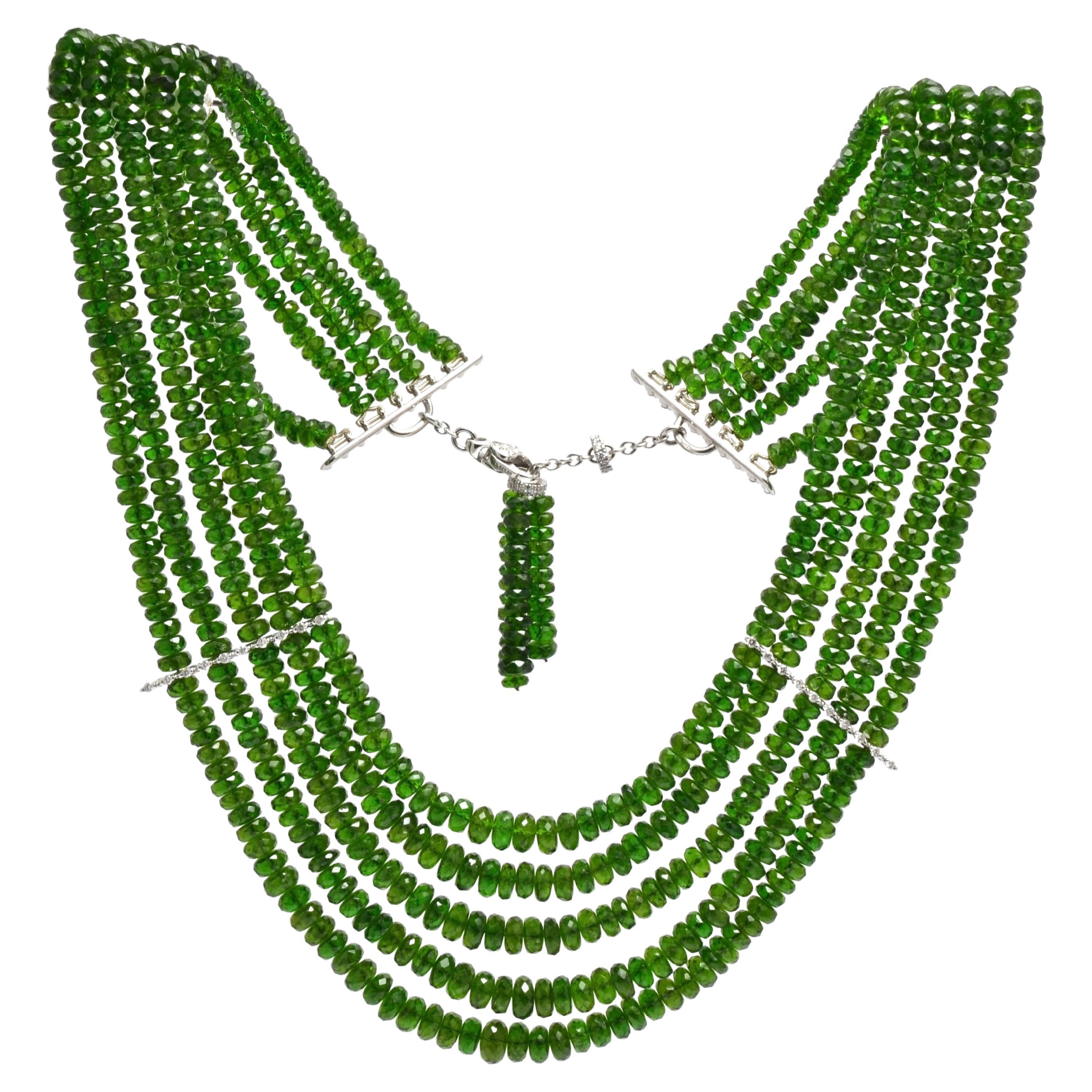 Vivid green tourmalines necklace featuring 5 strands of faceted degrade beads.
Detailed by two spacers of diamonds set on white gold.
Same style clasp, decorated by diamonds, decorated by a  tassel of green tourmalines.
Length is adjustable.
Elegant