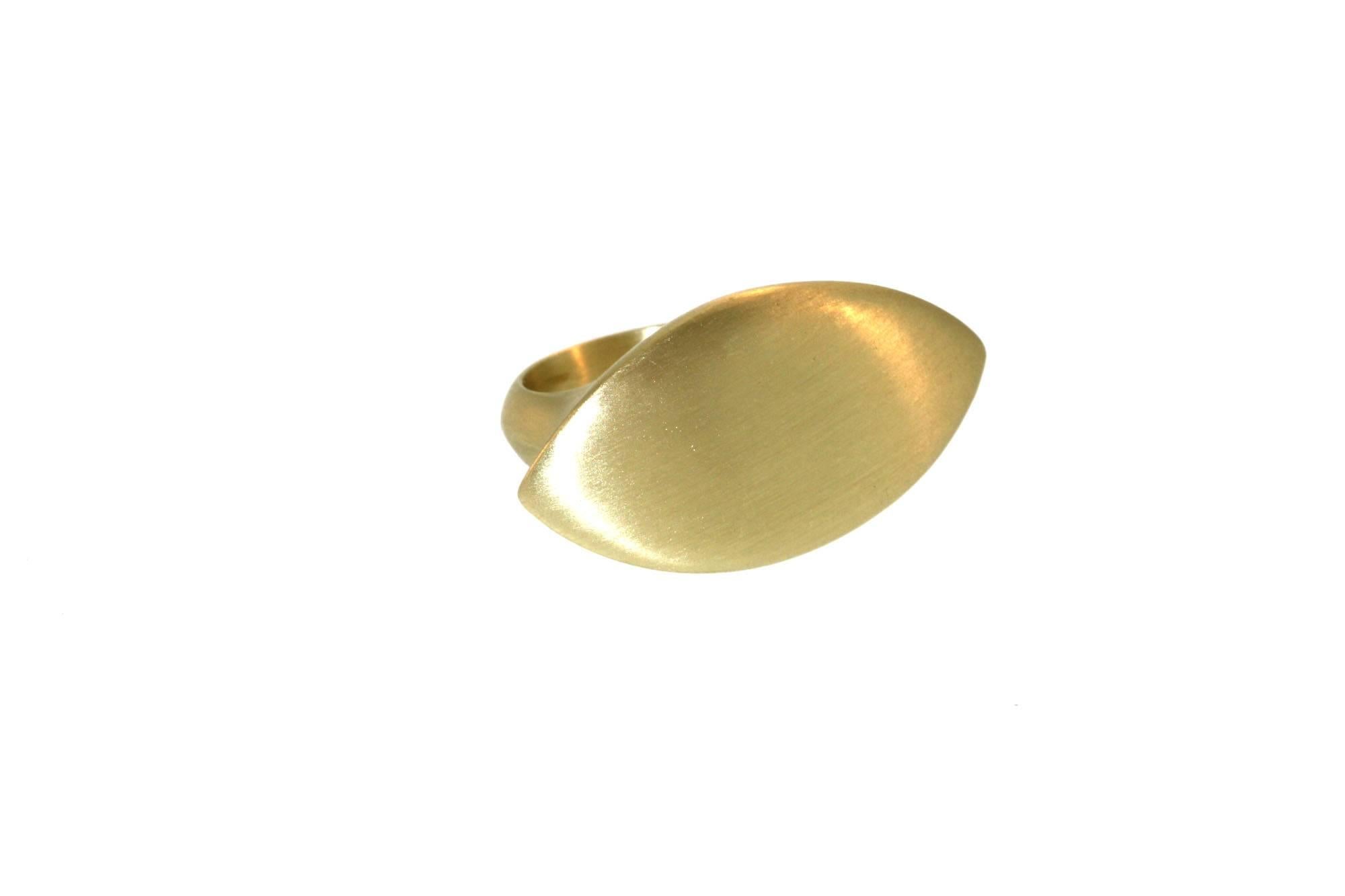 Smooth and seamless to the touch, this gold marquis ring makes a strong and chic statement. A great ring for the middle finger as it overlaps onto the index and ring finger, and could also be stacked with other rings. This ring has a substantial