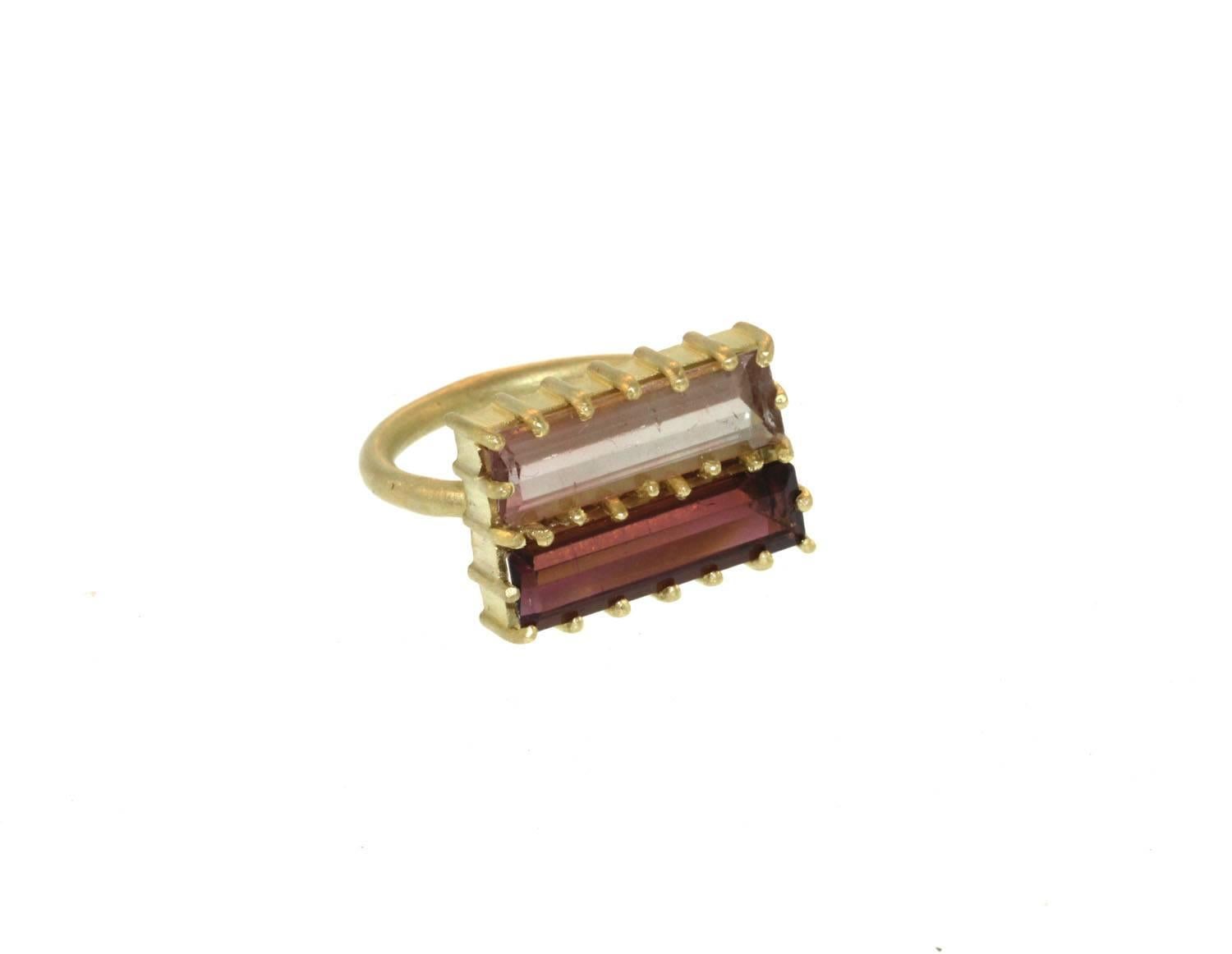 A striking ring with nice structure. This ring has two beautifully colored tourmaline baguettes prong set in 18k gold. One baguette has a light pink color while the other is of a darker mauve color. Each baguette measures approximately 18mm x 6mm.