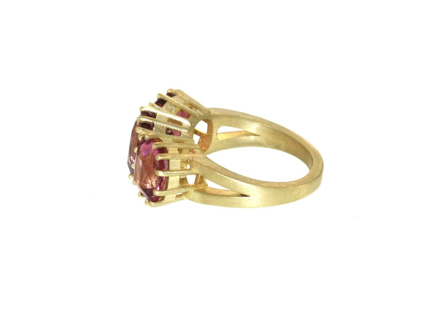 This triple pink tourmaline ring is mesmerizing. Three brilliant cut pink tourmalines, all of varying shades sit prong set side by side to create this triple stone ring. Each tourmaline is of an oval shape and has squared edges. Together all three