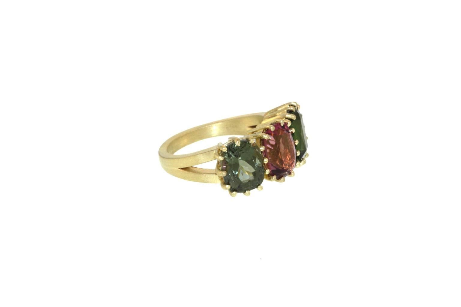 A perfect ring for fall! Three prong set tourmalines sit horizontally side by side to create a beautiful triple stone ring. Tourmalines of mixed colors, the center oval pink tourmaline rests in-between an oval teal tourmaline and a square green