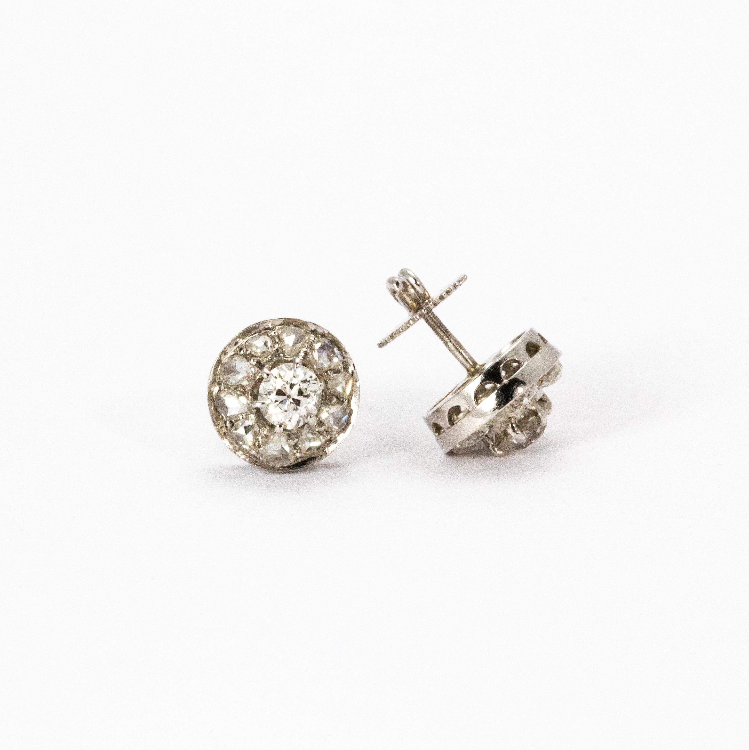 A pair of breathtaking vintage diamond earrings modelled in platinum with screw back fittings. Each earring hosts a central old European cut diamond measuring 30 points, surrounded by a halo of eight more brilliant white cut diamonds. 

Total