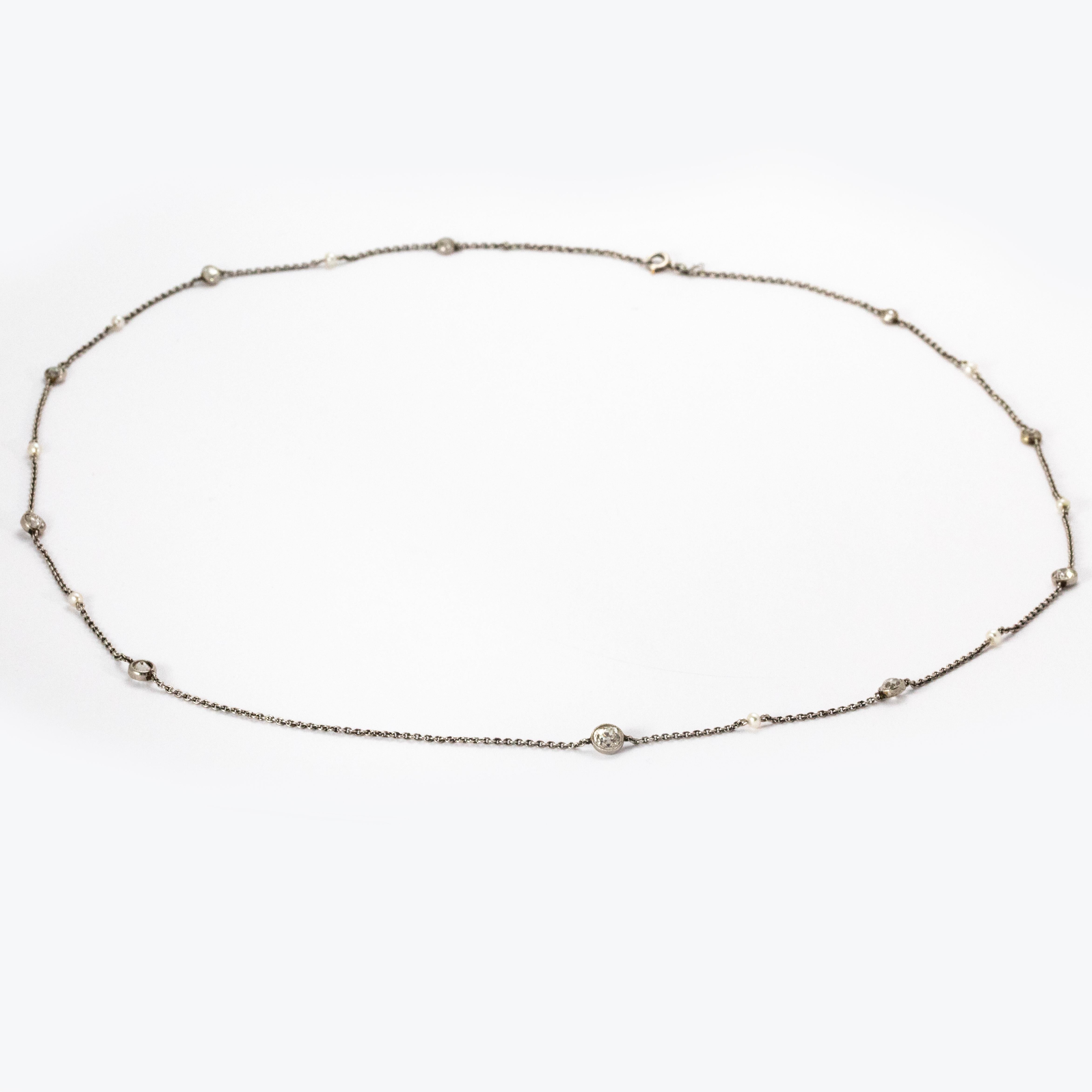 An elegant Art Deco chain necklace set with alternating diamonds and natural pearls, and modelled in platinum. This necklace boasts eight pearls and ten graduated diamonds, the largest of which weights 50 points.

Necklace Length: 22 inches