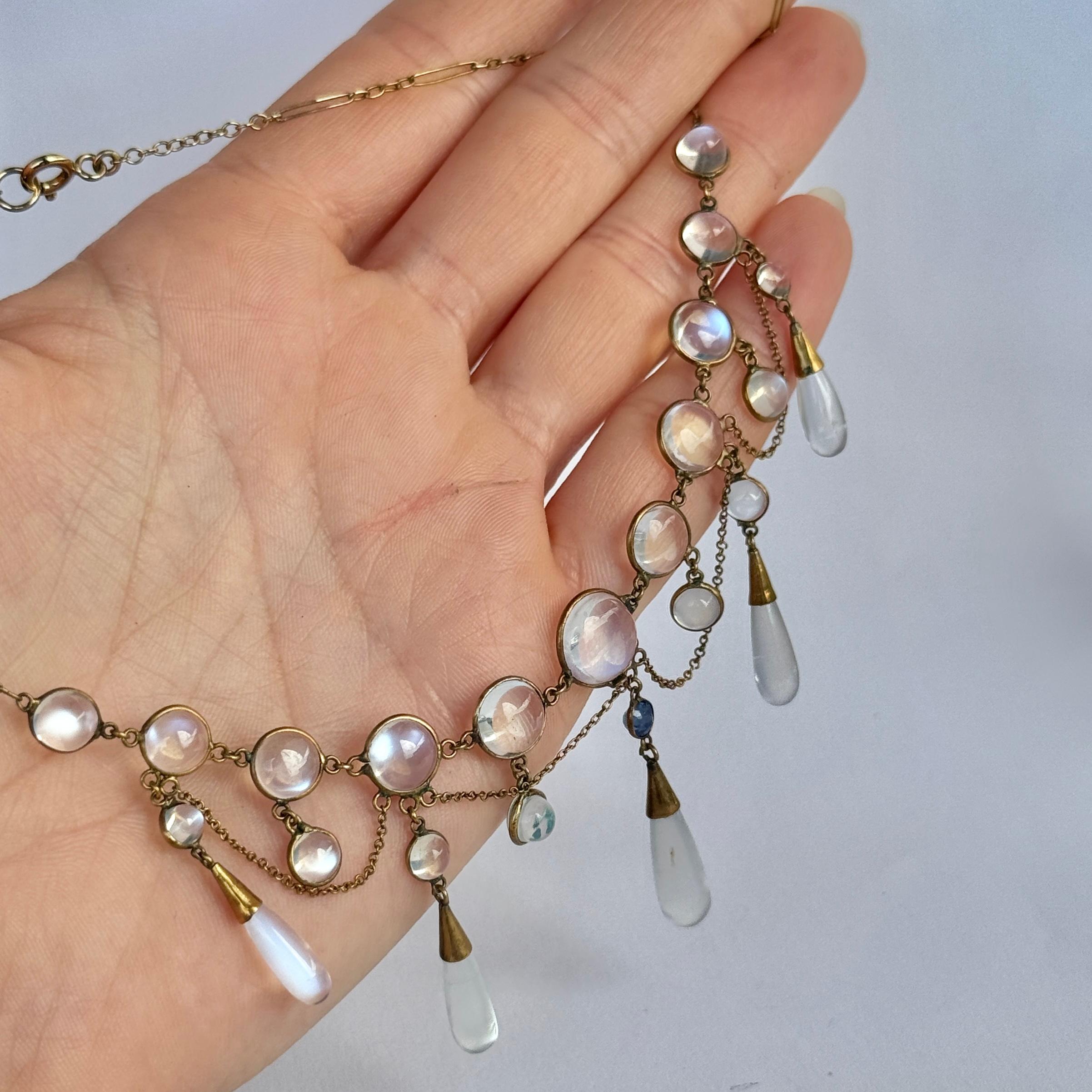Una squisita collana con frange di pietra di luna. La catena in oro 9 carati è incastonata con cabochon e gocce di pietra di luna. Al centro della collana c'è uno zaffiro di 20 carati.

Lunghezza della catena: 42 cm
Lunghezza della goccia centrale: