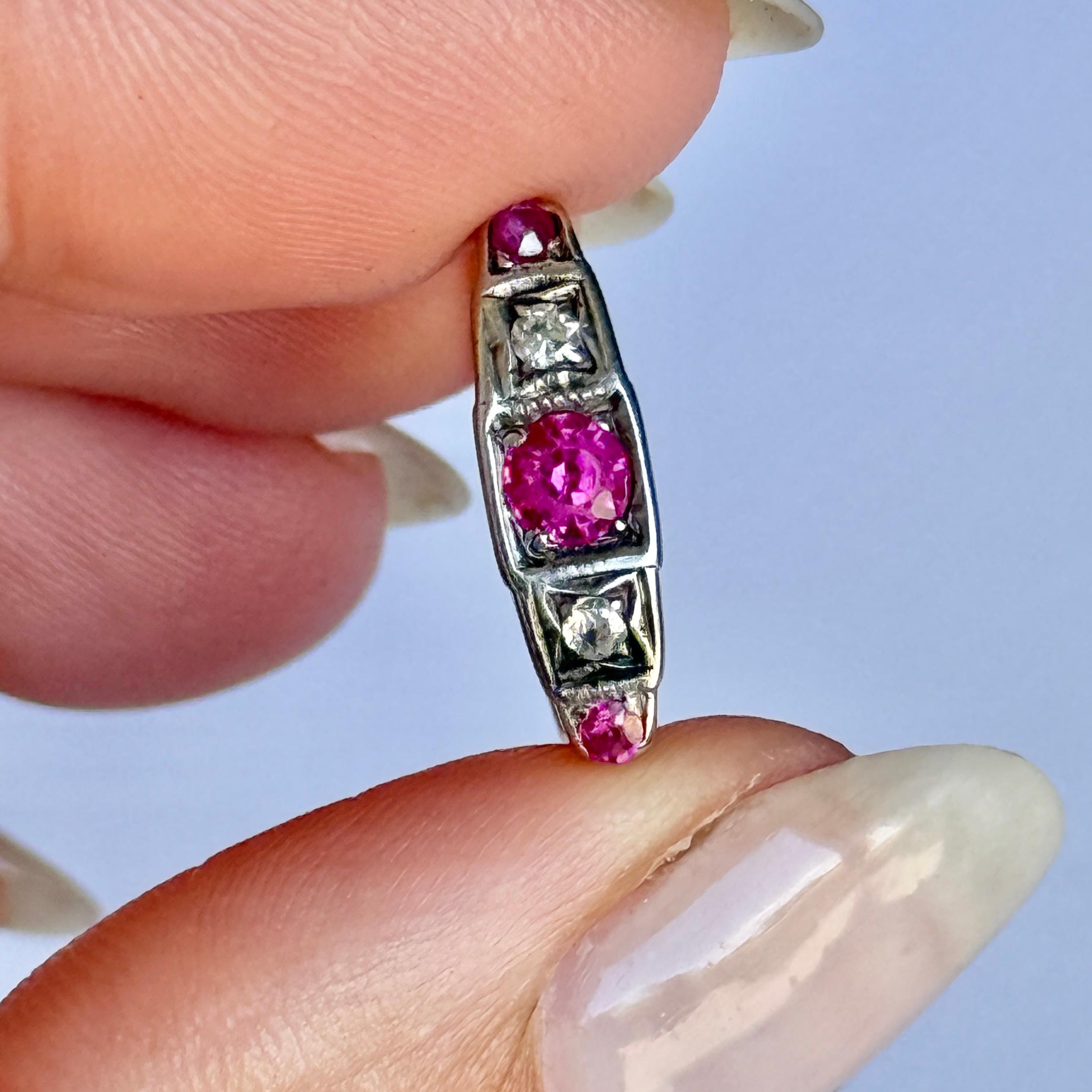 Magnifique bague vintage à cinq pierres de la période Art Deco, vers 1920. Le rubis central mesure 20 points et est flanqué de deux beaux diamants de 5 points. Les pierres sont serties dans de l'or blanc et une étonnante galerie triangulaire. Modèle
