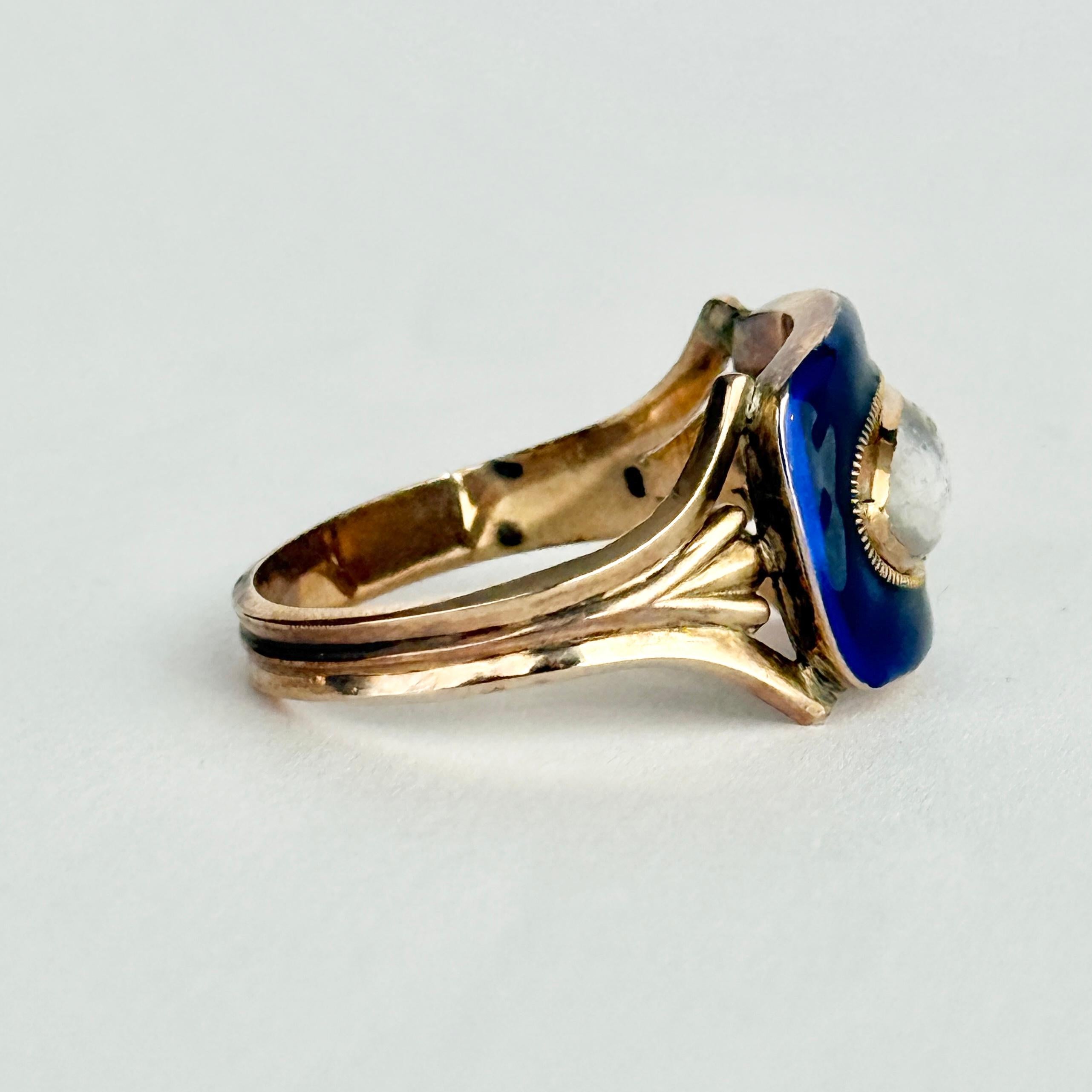 Llamativo esmalte azul que rodea un brillante cristal cabujón. Esta belleza victoriana está modelada en oro y tiene grabadas las iniciales E.A. debajo del panel principal. 

Tamaño del anillo: T o 9 1/2 
Dimensiones de la cara: 12 mm x 15,5 mm 