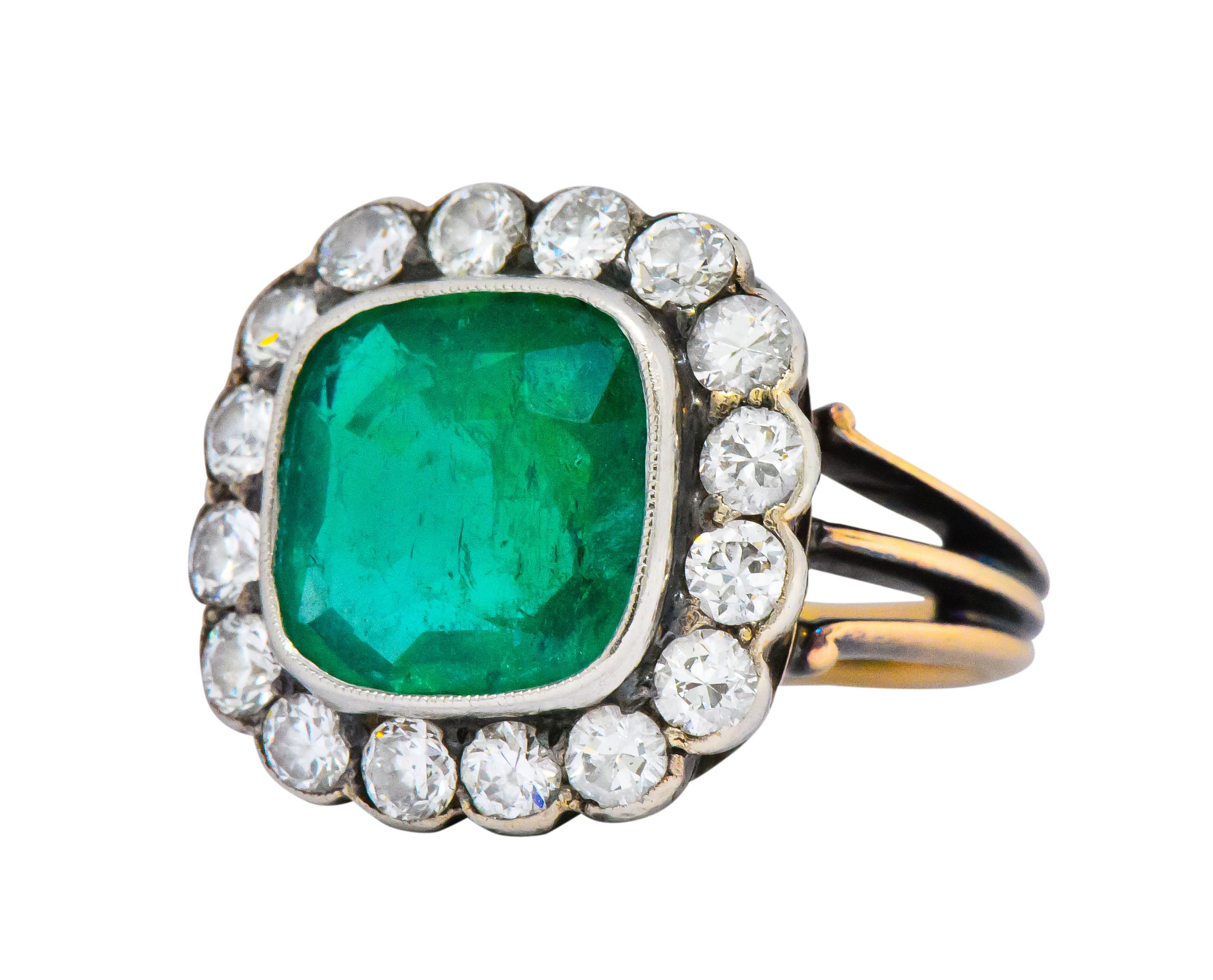 Centering a square cushion cut emerald weighing approximately 3.25 carats, bright vivid green

With an old European cut diamond surround weighing approximately 1.60 carats, GHI color and VS to SI clarity

With a tri-split and grooved shank

Tested