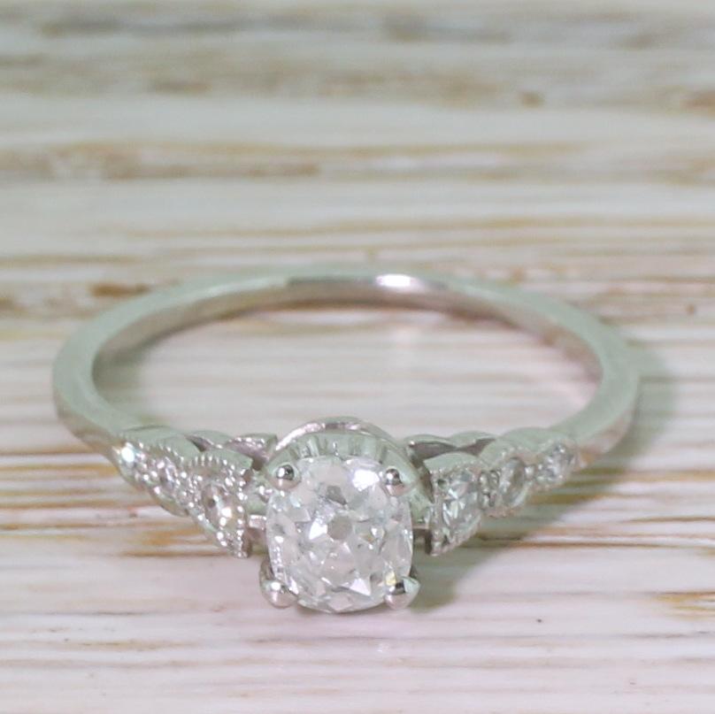 An astonishingly beautiful Art Deco engagement ring. The cushion shaped old cut diamond in the centre – graded by HRD as H colour, SI2 clarity – is high white, eye clean and absolutely glinting with life and sparkle. The stone is secured in a four