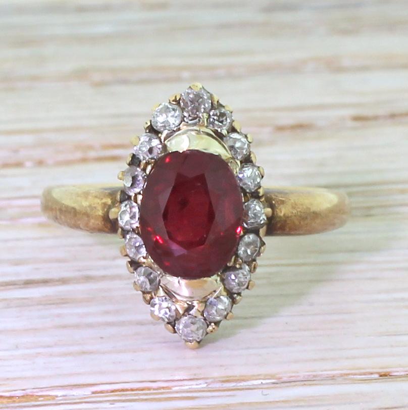 A beautiful and rather unusual navette ring, dominated by a sumptuous blood red oval cut ruby. Surrounded by a sixteen old mine cut diamonds on an incredibly finely pierced gallery leading to a solid, substantial D-shaped band. A striking design