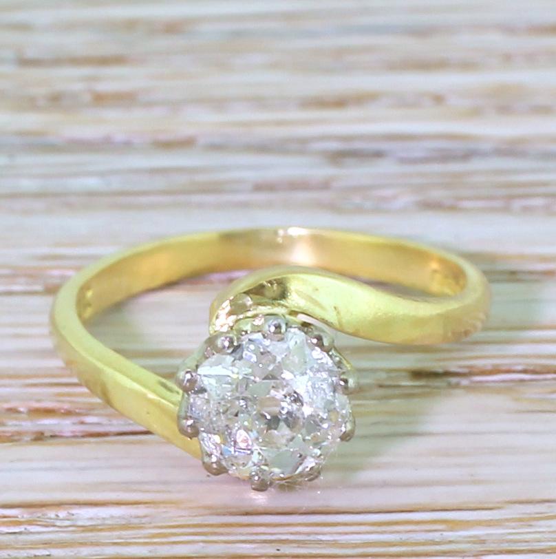 A bright and sparkly old cut diamond engagement ring. Despite being graded as I1, the centre stone is clean to the naked eye and bursts with fire and brilliance. The diamond is secured in a ten claw crown collet which is embraced by a sweeping
