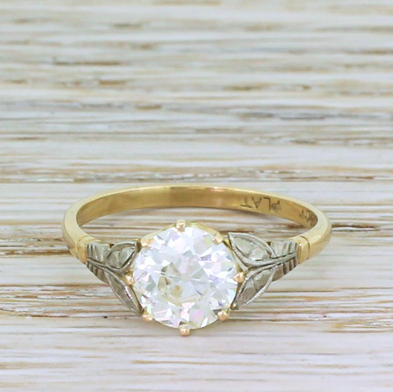 Breathtaking. This phenomenally beautiful vintage engagement ring features a glowing old European cut diamond in the centre, graded by HRD as K colour, VS2 clarity. The stone is secured in a yellow gold eight-claw coronet collet that sits nice and