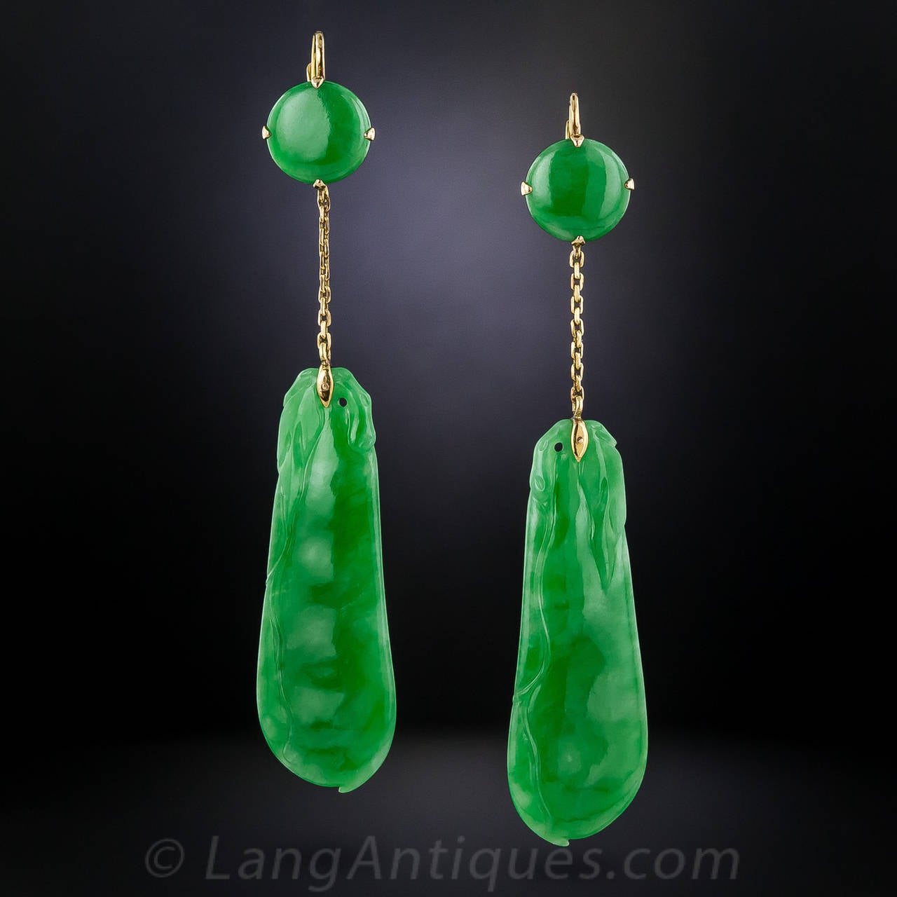 We've encountered few, if any, carved jade earrings to rival this fabulous pair, comprised of four luscious, bright green, natural jades: one pair of 1 and 1/8 inch long carvings surmounted by another pair of round buttons, connected by a gold