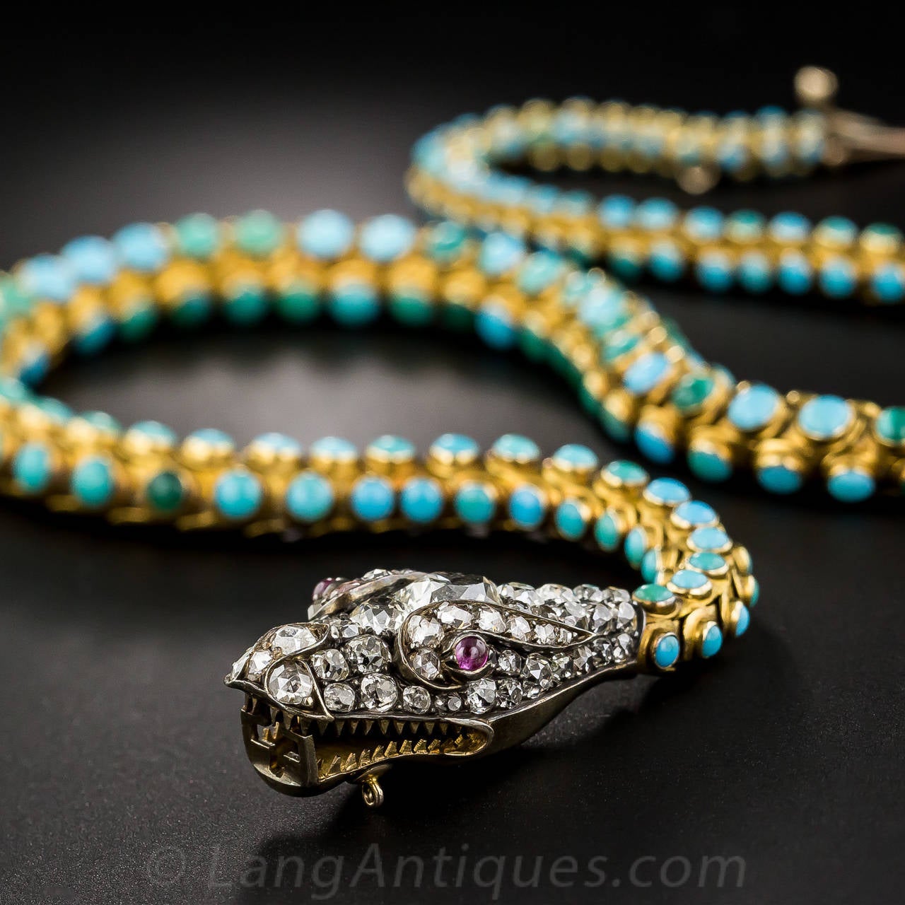A fabulous nineteenth-century serpent, her silver head aglitter with 4 carats of bright, sparkling white old mine-cut diamonds (including an almost one carat pear shape), is customarily swallowing its own lithe and supple tail, this one composed of
