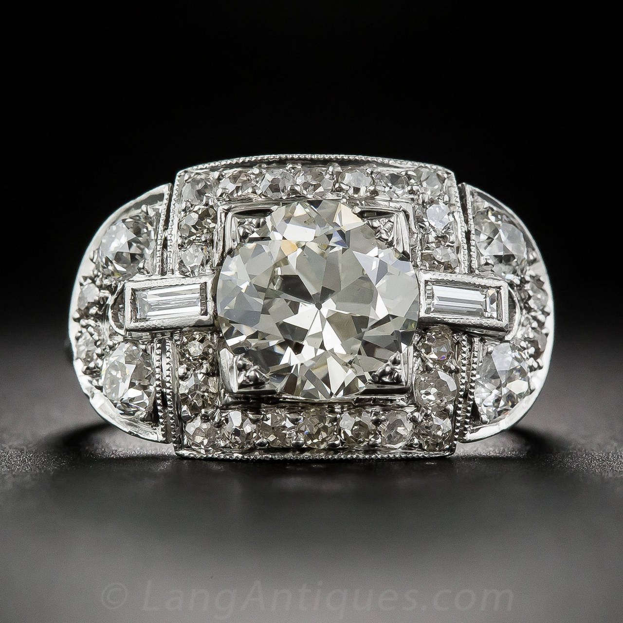 This remarkable, show stopping Art Deco ring dates to the Jazz Age in the Roaring '20s.The ring is hand crafted in luxurious platinum, sporting a comfortable, narrow shank, leading to the ring's ornate, diamond-set crown. The crown features an
