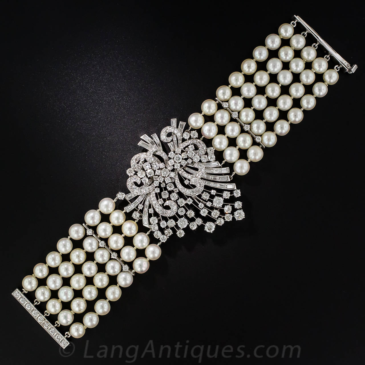 A dazzling fireworks display of super sparkling, bright-white, high-quality, round full-cut and baguette diamonds - totaling 14.50 carats - explodes in the center of this stunning and extravagantly glamorous 5-strand pearl bracelet, dating from the