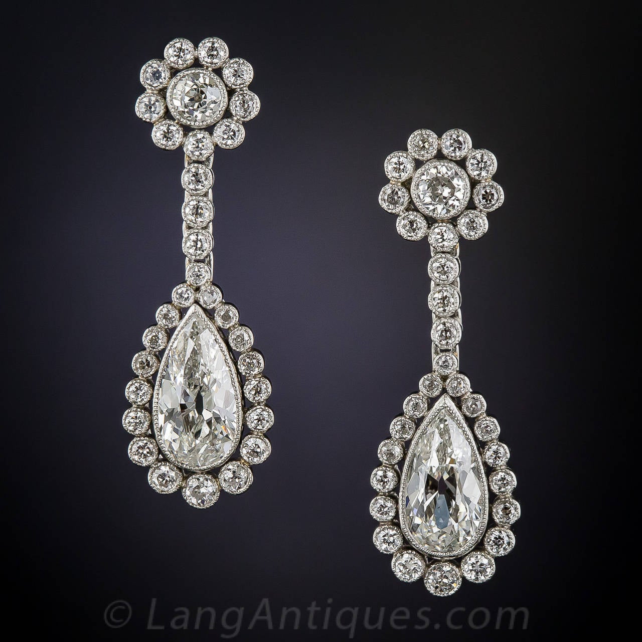 Perfect and perennial Edwardian style elegance for the modern muse! This sophisticated and sparkling pair of platinum earrings feature a resplendent pair of eloquently elongated and perfectly matched pear shaped diamonds (circa 1920) - weighing a