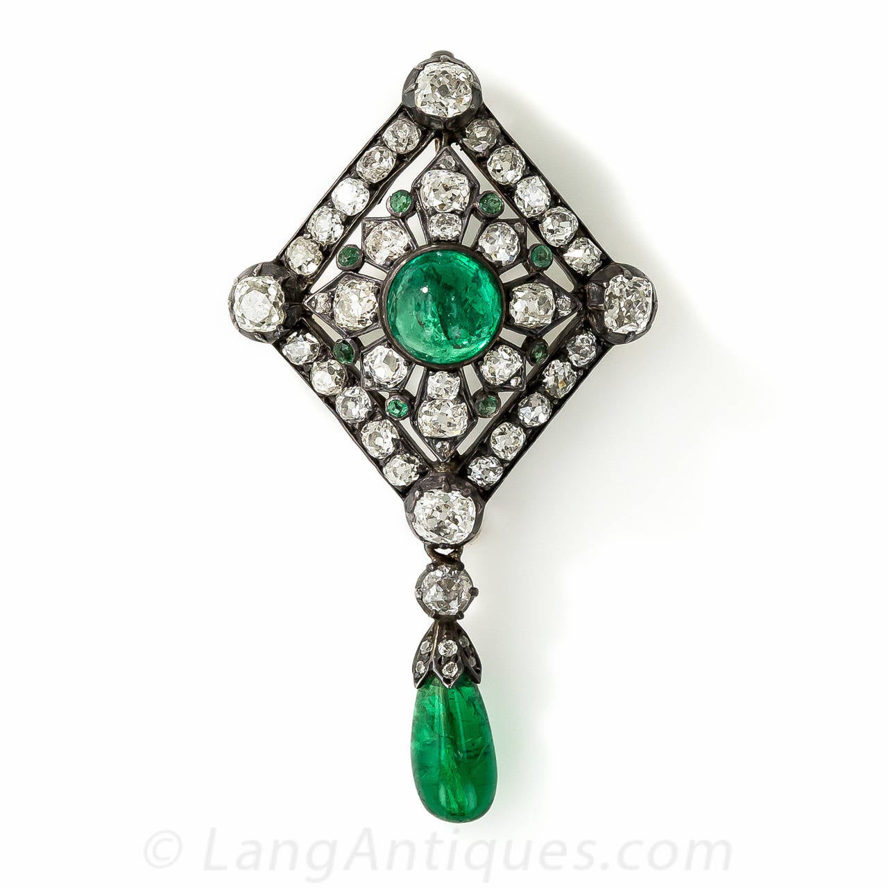 A truly exquisite gem dating from the mid-19th century, this original Victorian pin and pendant features two gorgeous green emeralds, together totaling over 8 carats, and 5.50 carats of bright white and lively old mine-cut diamonds. The central