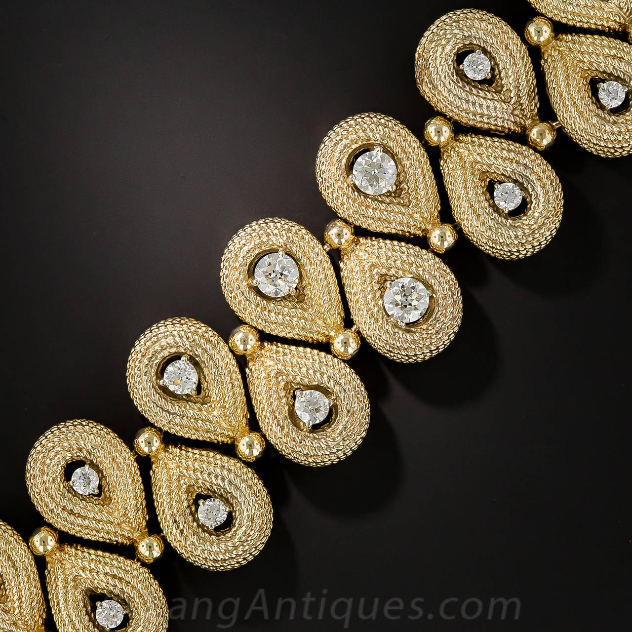 A double row of 11 highly textured 14K pear-shaped links (22 total), each centered with a sparkling white European-cut diamond (evidently extracted and repurposed from an early-20th-century piece of jewelry), comprise this bold and beautiful