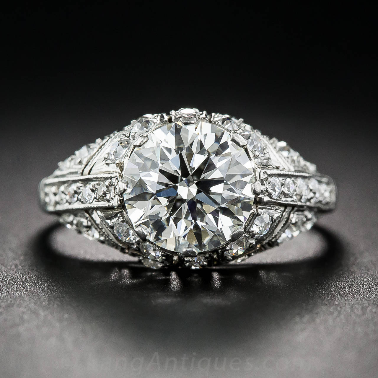 A bright and beautiful round brilliant-cut diamond, weighing 2.08 carats, is spectacularly displayed in this sparkling and sophisticated, high-profile mounting, hand fabricated in platinum , in faithful emulation of enduring 1920s Art Deco style.