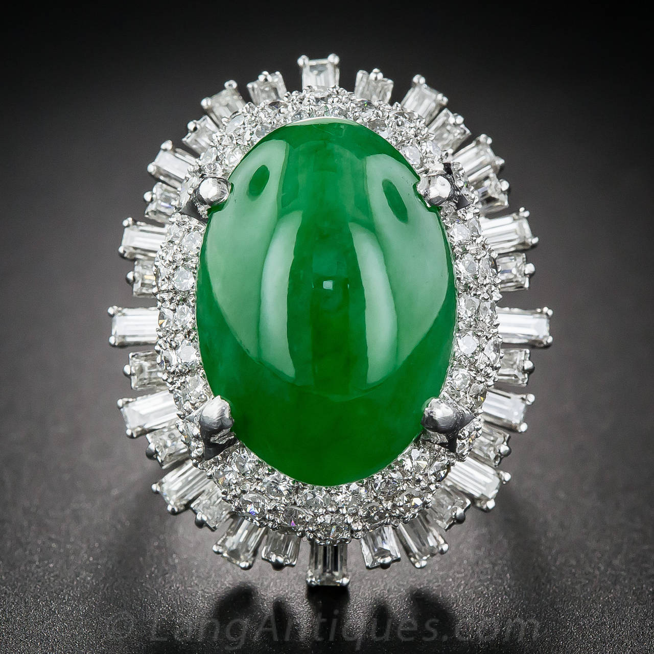 By way of mid-twentieth century Asia, most likely Hong Kong, comes this impressively proportioned cocktail ring, crafted in platinum and highlighting a vibrant, richly saturated, grassy green, oval cabochon jadeite, measuring 18.38 x 13.05 x 6.79
