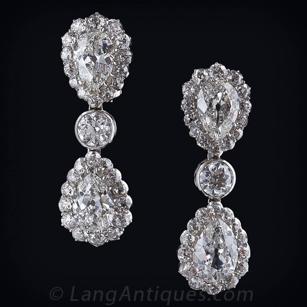 Four gorgeous antique pear shape diamonds, weighing 8.00 carats total, swathed in a row of European-cut diamonds, are set tip to tip separated by a bezel set .50 carat European-cut diamond in these truly magnificent and regal 1 1/2 inch long drop