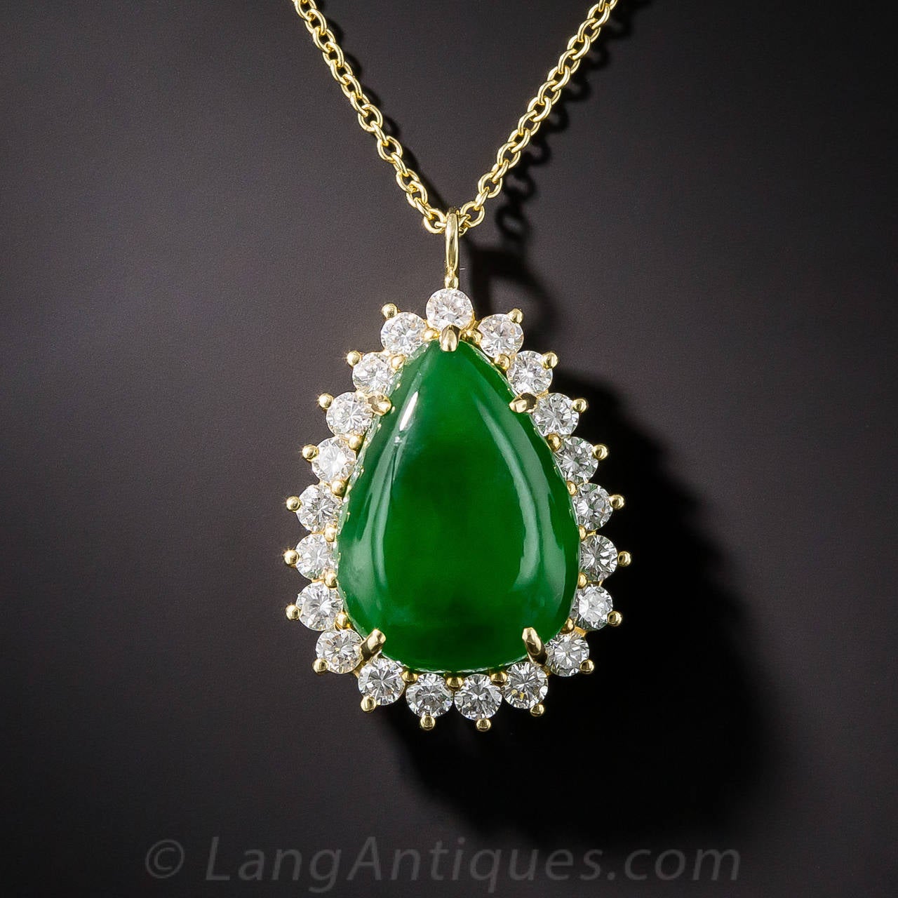 A gorgeous, rich green, pear shape jade of substantial thickness and translucence is elegantly displayed in a sparkling frame of high-quality, icy-white, full-cut diamonds in this exceptional and exceptionally beautiful pendant necklace by America's