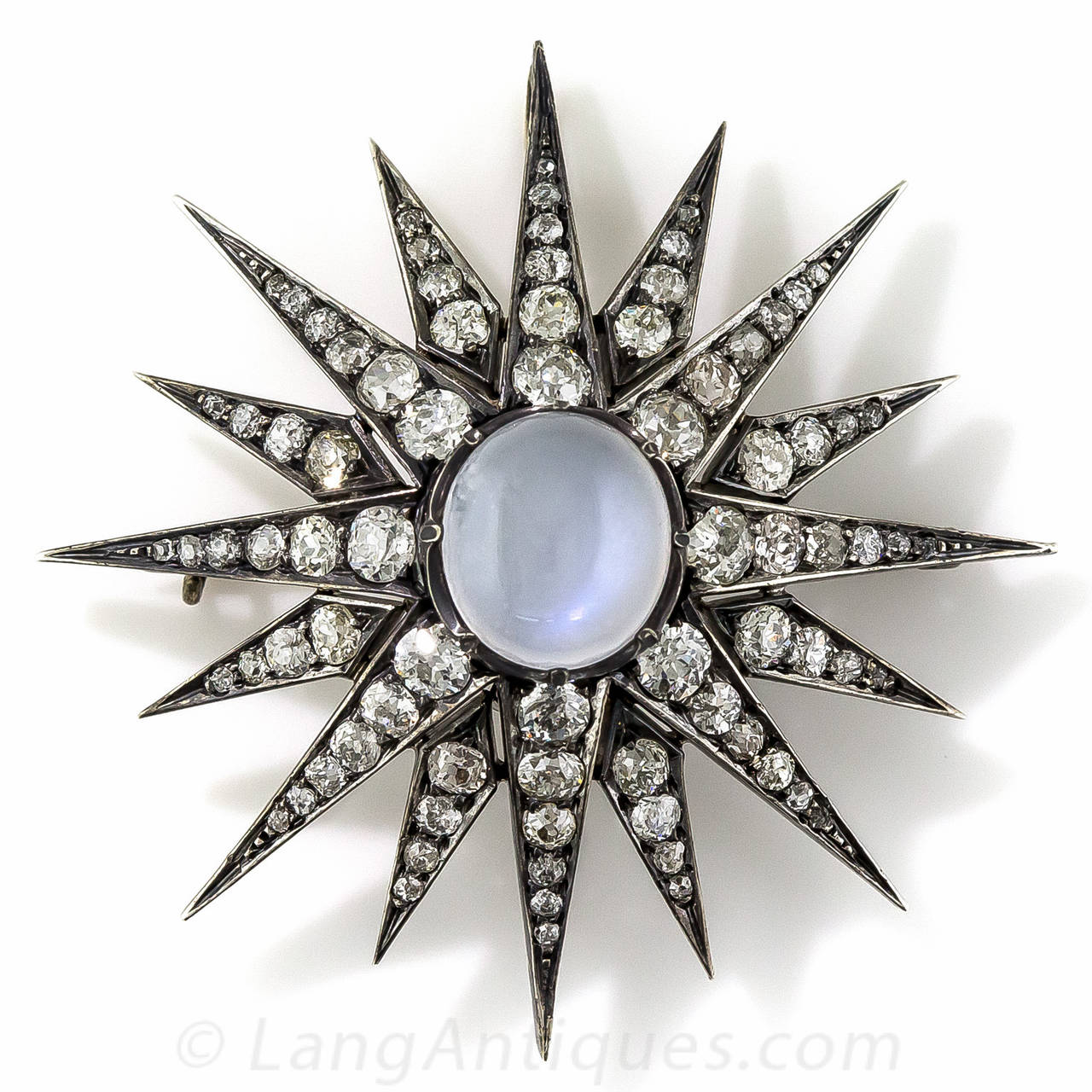 Why settle for just one when you can have both the moon and the stars?! This celestial Victorian jewel, measuring just over 2 inches across, centers on a shimmering blue flash moonstone from which radiates 16 rays, packed to the hilt with 5 carats