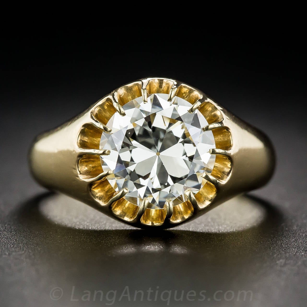 Strikingly and elegantly simple, a warm and glowing European-cut diamond, weighing 3.03 carats, displaying a faint tinge of sunshiny yellow, scintillates solo from within a scalloped circle of prongs in this high polished, richly colored, 18 karat