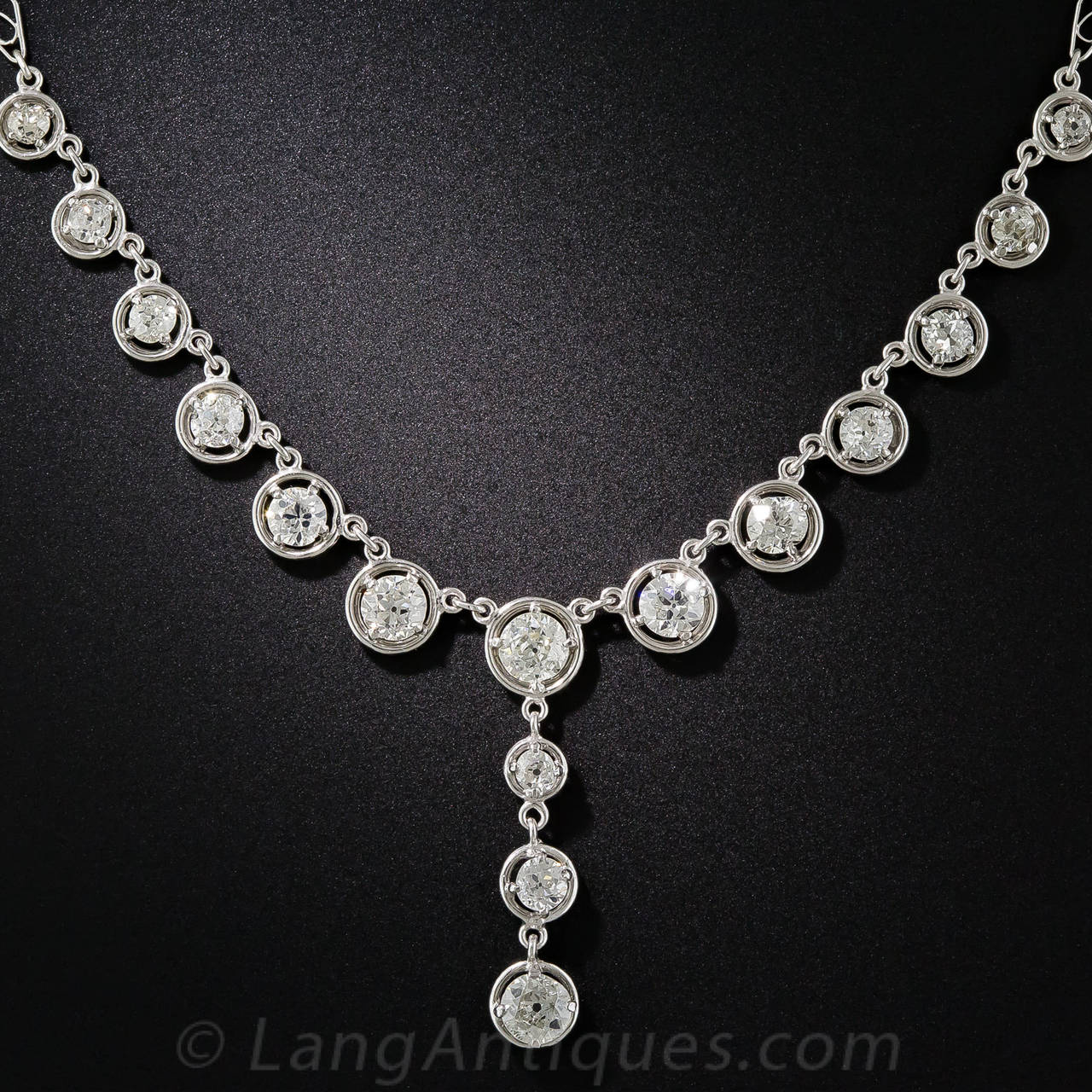 Masterfully hand fabricated and utterly bedazzling in platinum, this early Art Deco diamond necklace - circa 1920 - sparkles brilliantly with 24 'compass-set' diamonds, totaling 4.15 carats, attached to a diamond studded infinity style chain. The