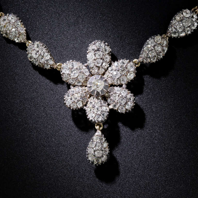 This rare and ravishing mid-nineteenth century diamond necklace, handcrafted in warmly oxidized silver over 9 karat gold (thus most likely of British origin) blossoms with over five carats of closely set, bright-white, old mine-cut diamonds set into