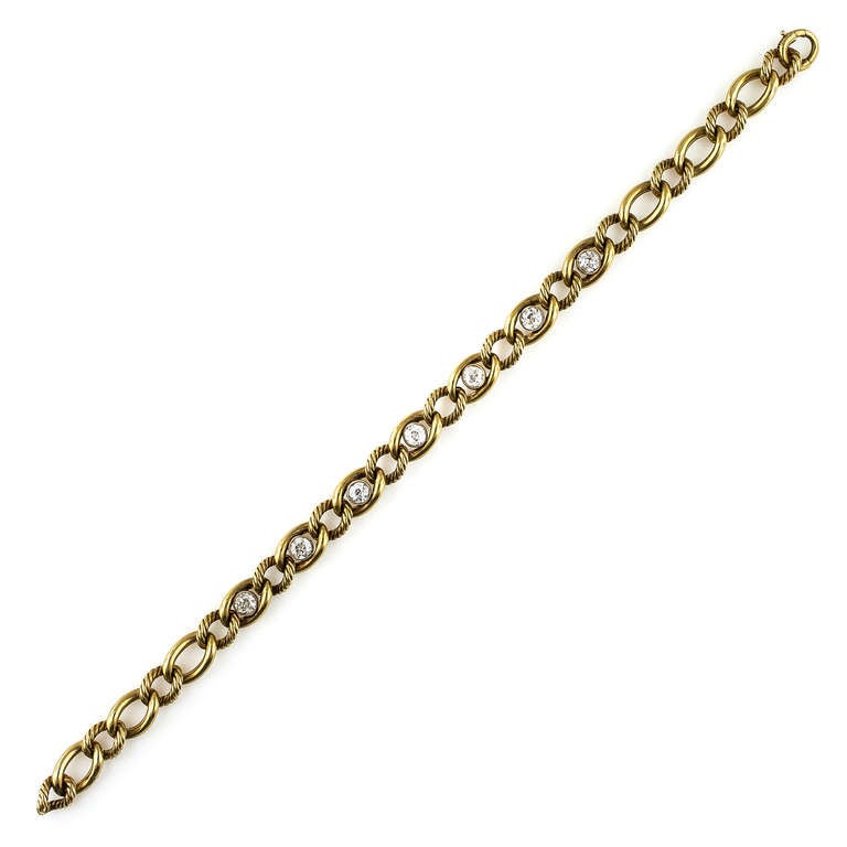 This superb and very rare antique bracelet from France by the world renowned Cartier is composed of alternating smooth and ribbed 18k yellow gold links, with a glossy finish to accentuate the glowing luster of 2 carats of dazzling European-cut