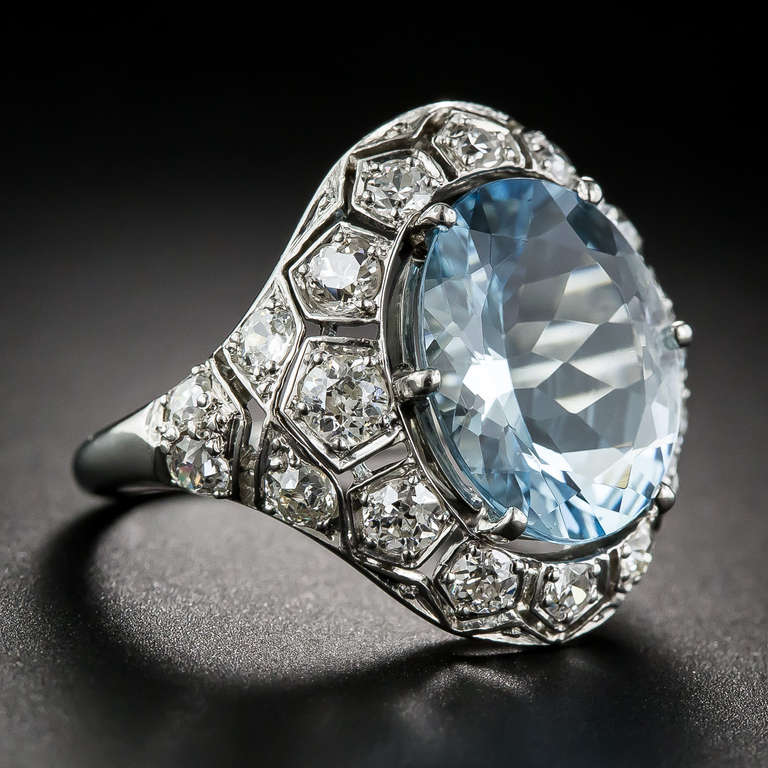 A refreshing splash of cool blue sparkles from the center of this unusual, impressive and thoroughly stunning aquamarine ring, hand fabricated in platinum - circa 1920s-30s. The glistening 4.55 carat gemstone is embraced all around with 1.35 carats