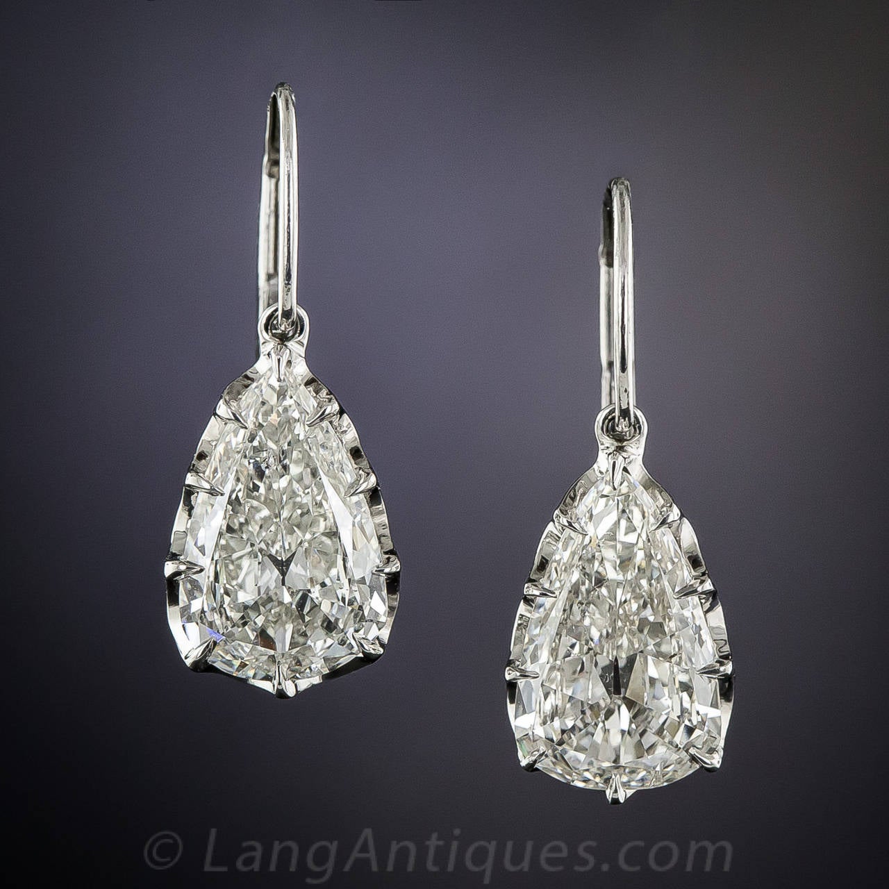 Magnifique! After acquiring this rare and radiant pair of vintage pear shape diamonds, weighing 1.69 and 1.60 carats respectively, 3.29 carats total (yet presenting about 2 carats each, due to their antique cuts), we commissioned one of our finest