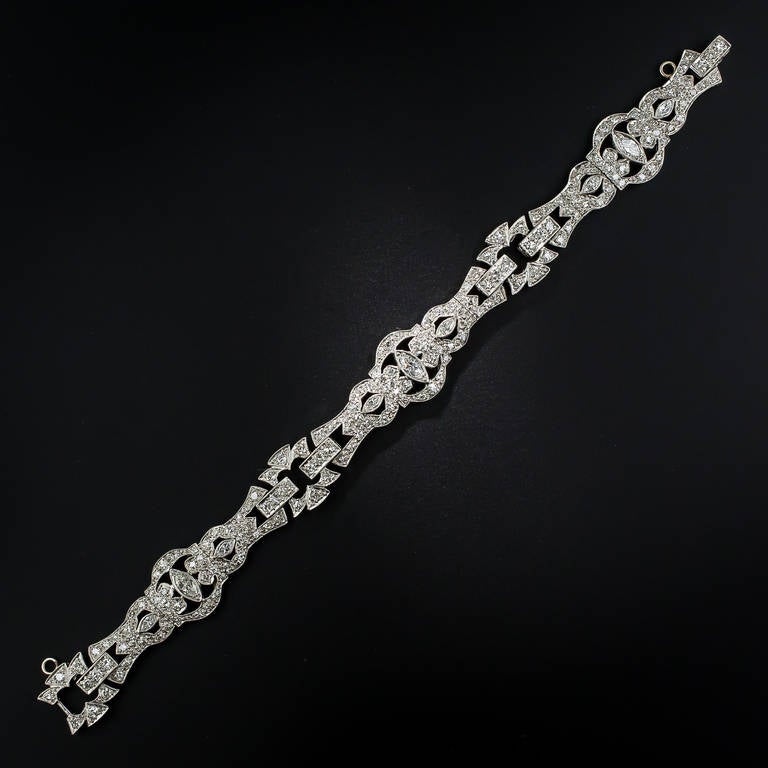 This all original, signed and numbered, Art Deco diamond bracelet, handcrafted in platinum, circa 1925, presents a big sparkling and sophisticated look for the price. The three-section design is centered on a gracefully elongated diamond-set section