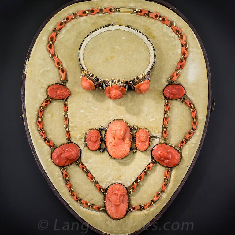 This ravishing, rare and wonderful suite of frutti de mare, by way of early-to-mid-19th century Italia, presents eleven deep orangy-salmon-colored coral cameos, carved in high relief, depicting as many classical Mediterranean beauties. The five