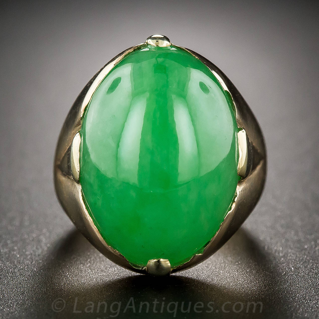 A big, bright and happy apple green, high-domed double-cabochon jade, authenticated as natural color by the Gemological Institute of America, and of substantial proportions - 18.34 x 13.41 x 7.69 millimeters - is simply presented in a rose gold