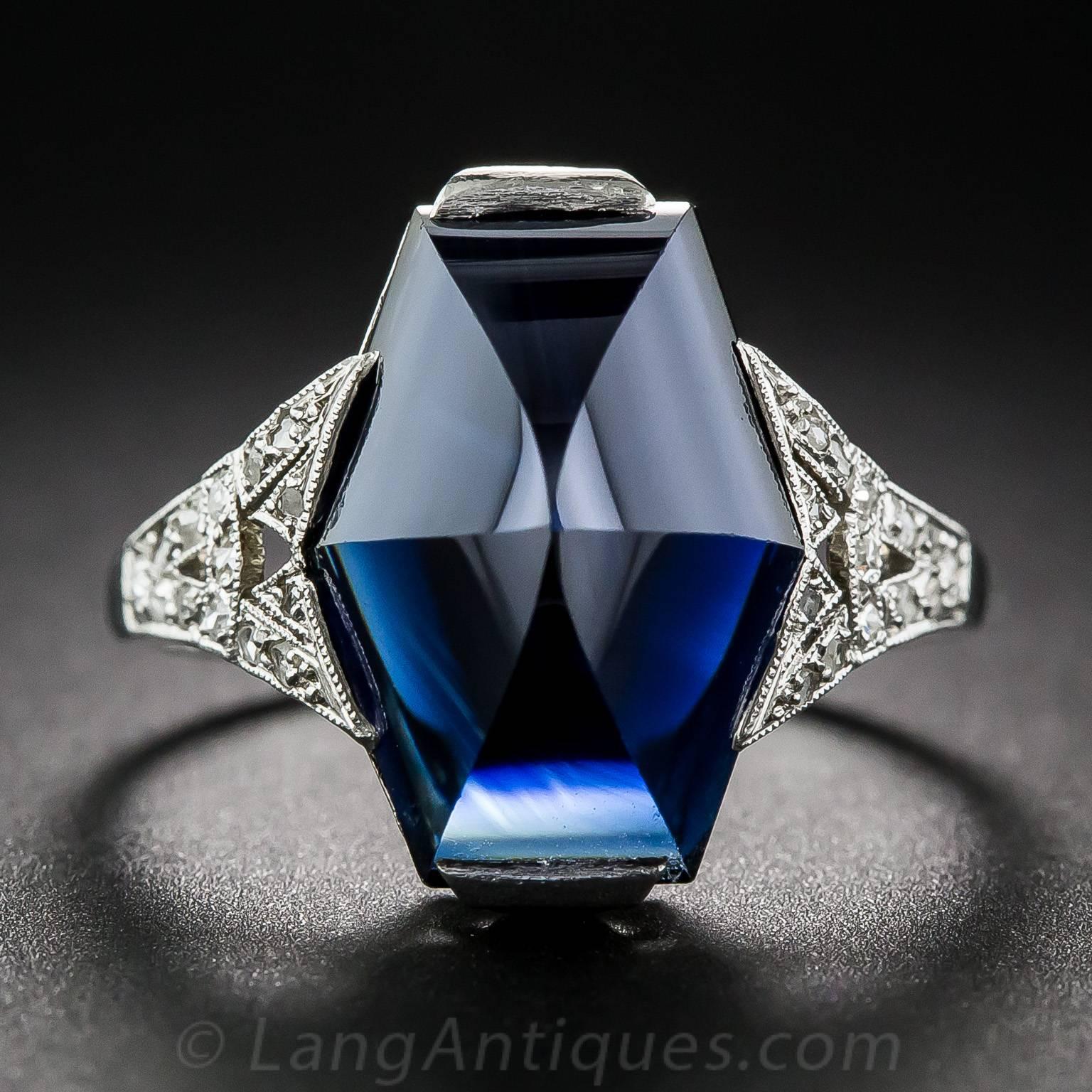 This striking French made ring, circa 1925, features a very special gemstone: a 7.25 carat sapphire fashioned into a faceted hexagonal buff-top cut. The dark midnight blue gemstone is presented in a gorgeous mounting, hand crafted in platinum with