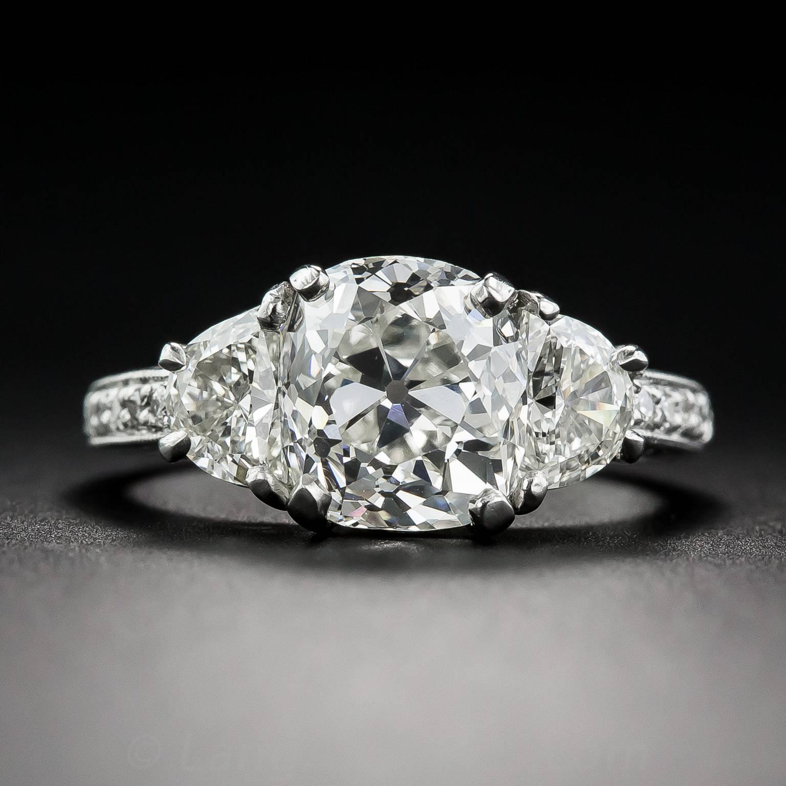 A gorgeous, bright white and beautiful 3.03 carat antique cushion-cut diamond, of early twentieth century vintage, has found a fabulous new home between a matched pair of half-moon diamonds, together weighing an additional 1 carat. The scintillating