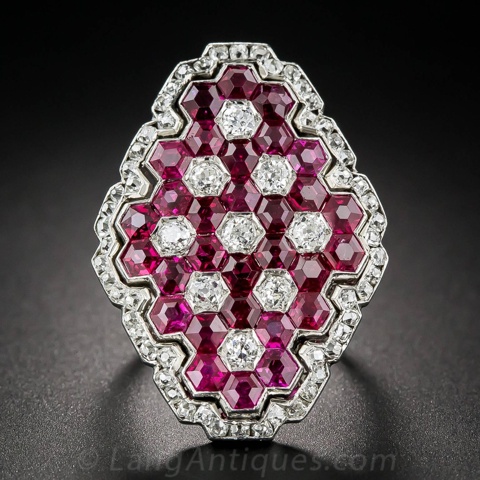 An ultra-fine and simply spectacular, large (1 and 3/16 inch long) lozenge-shape Art Deco dinner ring glistening with 30 hexagonal-cut, deep, rich, red Burmese rubies, punctuated with old mine-cut diamonds, all arranged in a striking geometric