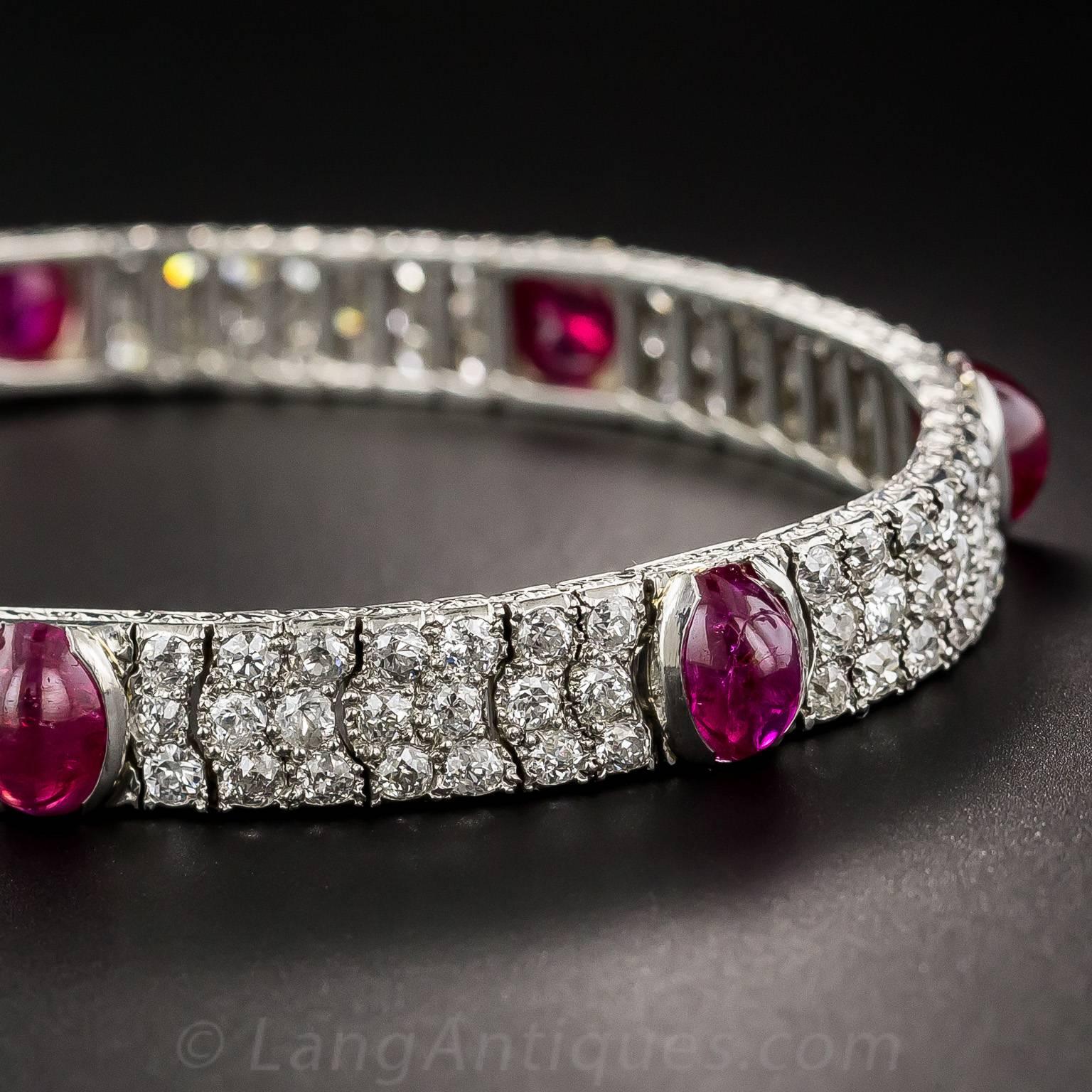 Seven rich, strawberry red, cabochon rubies, together weighing over 10 carats, glow between wavy diamond-set links in this exceptional original Art Deco bracelet, dating from the peak of the period - circa 1925. The quarter-inch wide bracelet