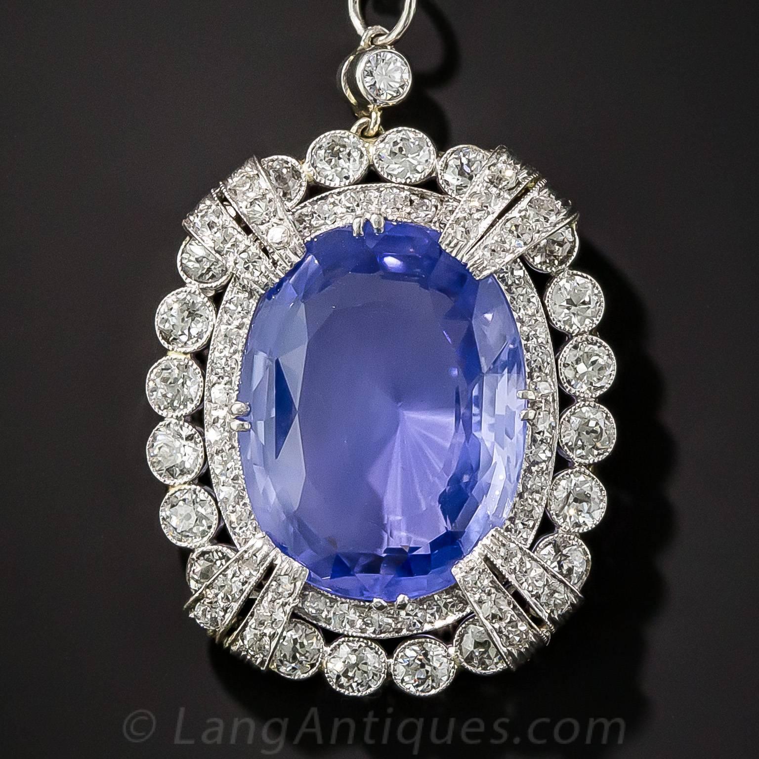 This regal Art Deco showstopper, dating from the 1920s, magnificently displays a crystalline, cornflower blue, natural, no-heat Ceylon sapphire, presenting about double the size of its (measured) 15.65 carat weight. The impressive and enchanting