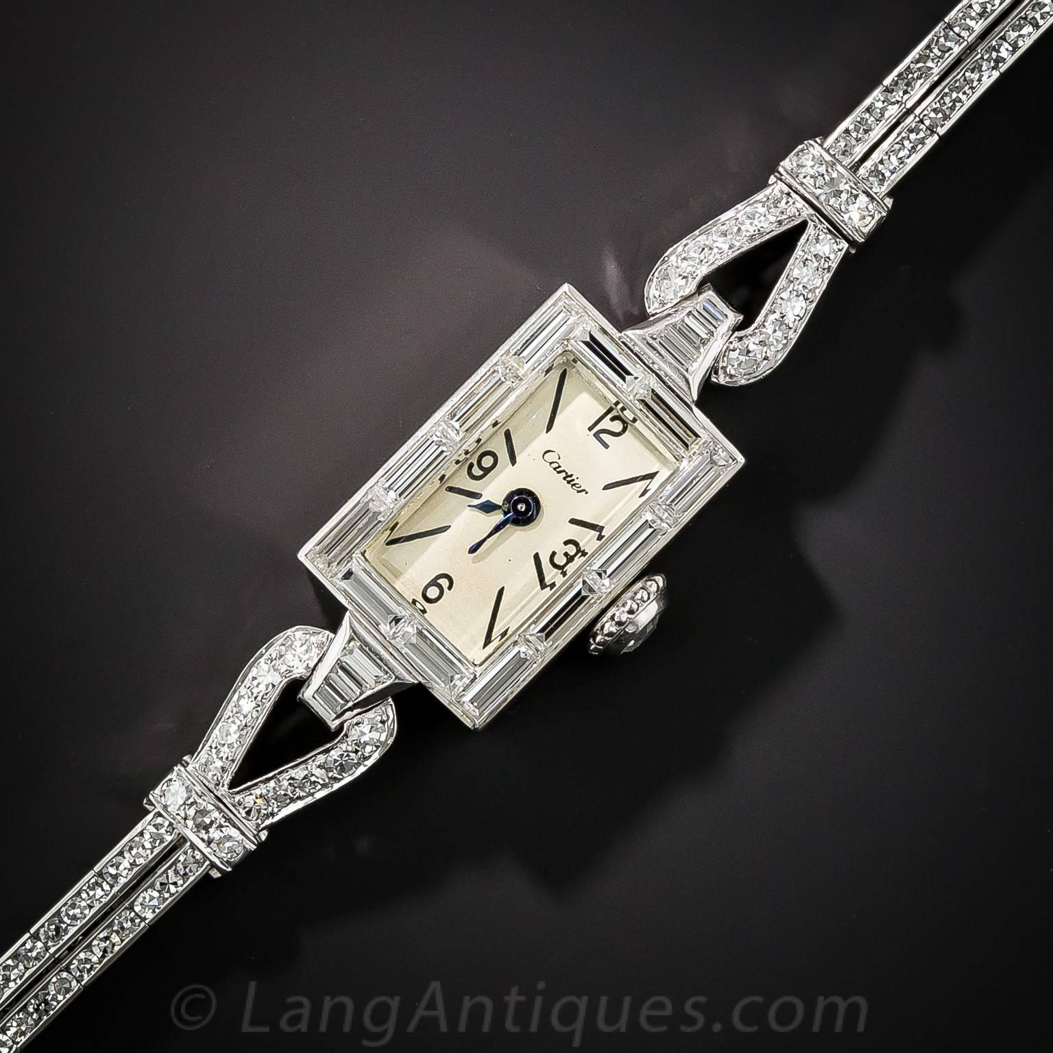 A sleek, stylish and sexy bracelet watch dating from the mid- twentieth century, superbly crafted in platinum by Cartier. The rectangular timepiece is framed in glistening baguette diamonds and transitions, via stirrup motifs, into a slender double