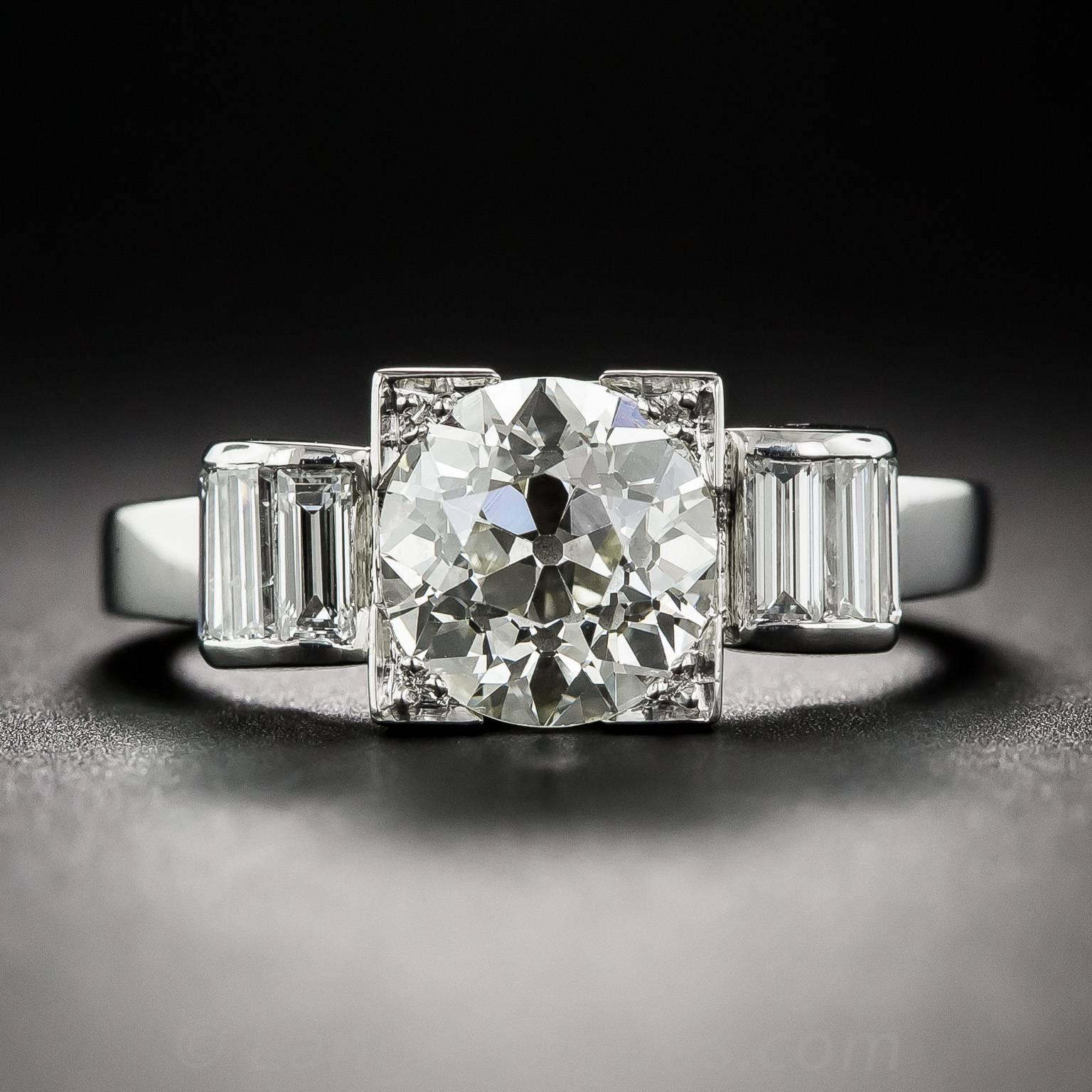 Architectural elegance with a modern twist defines this classic, original Art Deco engagement ring dating from the 1920s.  Looking large and sumptuous, a bright and shining European-cut diamond, weighing 2.50 carats, radiates from within a square