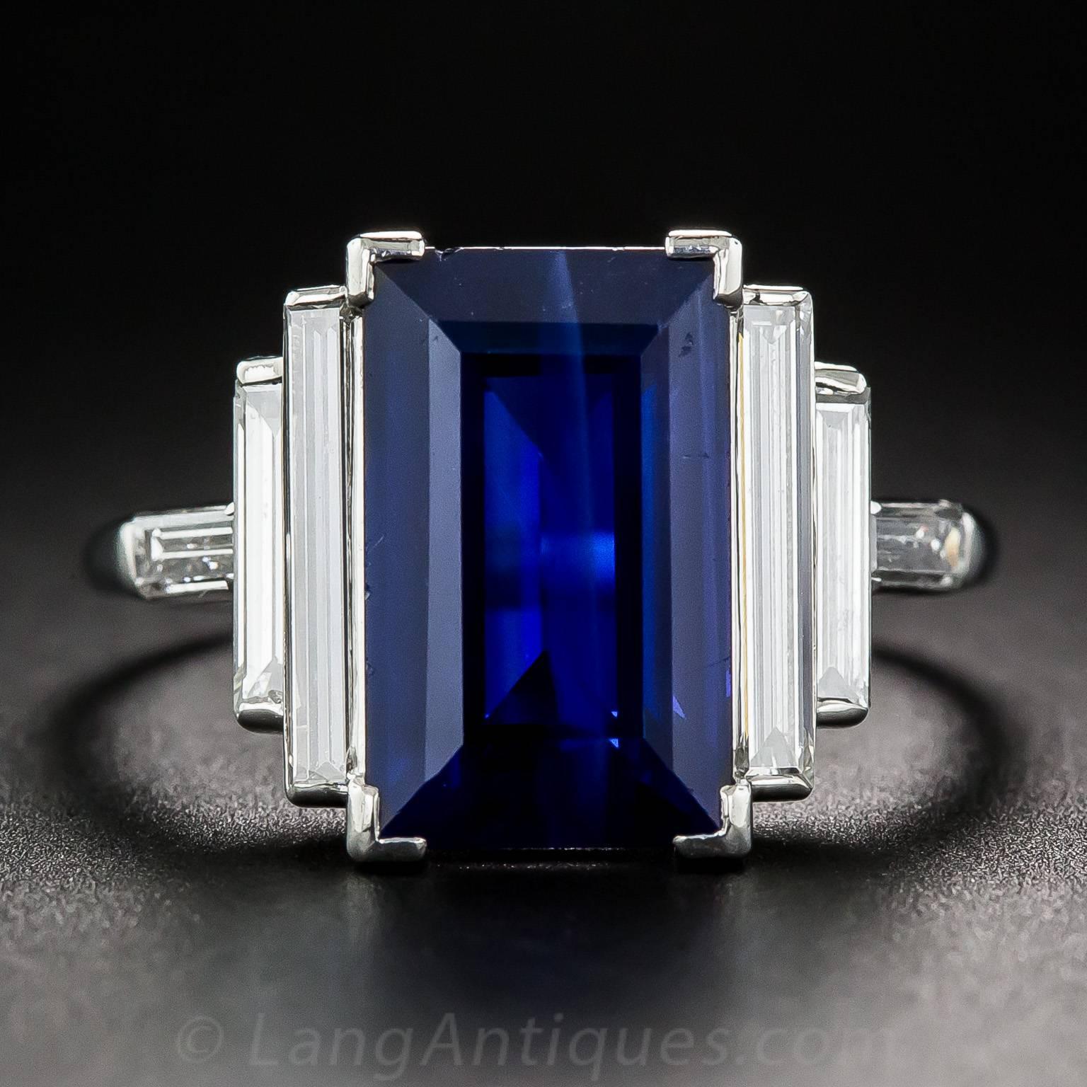 Sleek, sophisticated and sexy. A long and lovely emerald-cut sapphire, weighing 5 carats and exhibiting a rich royal blue hue, glistens between two pairs of extra-long and slender straight baguette diamonds, plus a perpendicular pair enlivening the