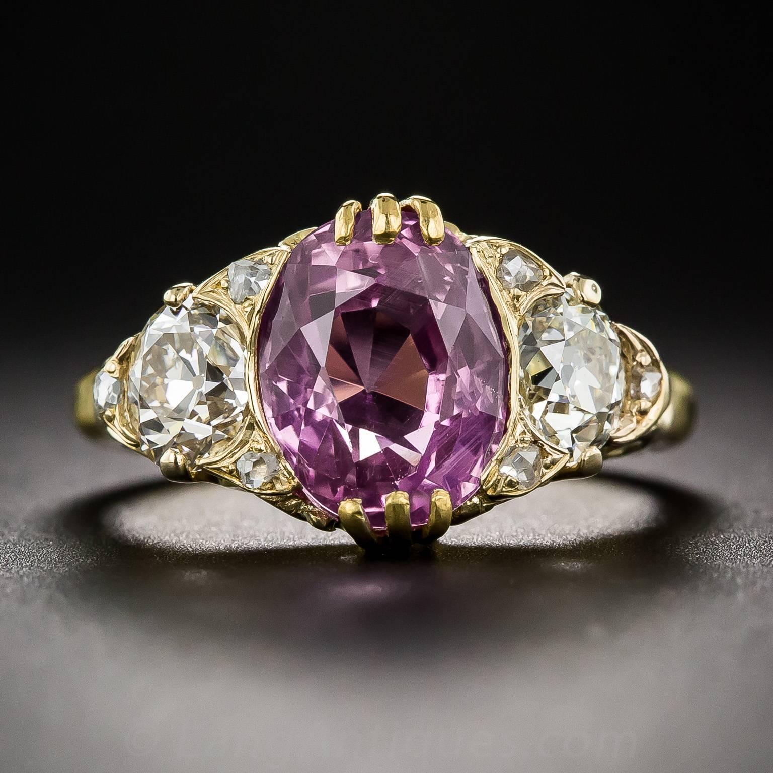 A thoroughly enchanting lavender pink sapphire, weighing 4.50 carats, natural color, no-heat treatment and of old Ceylon origin, glistens and glows between a pair of bright white old mine-cut diamonds (together weighing 1.25 carats), in this classic