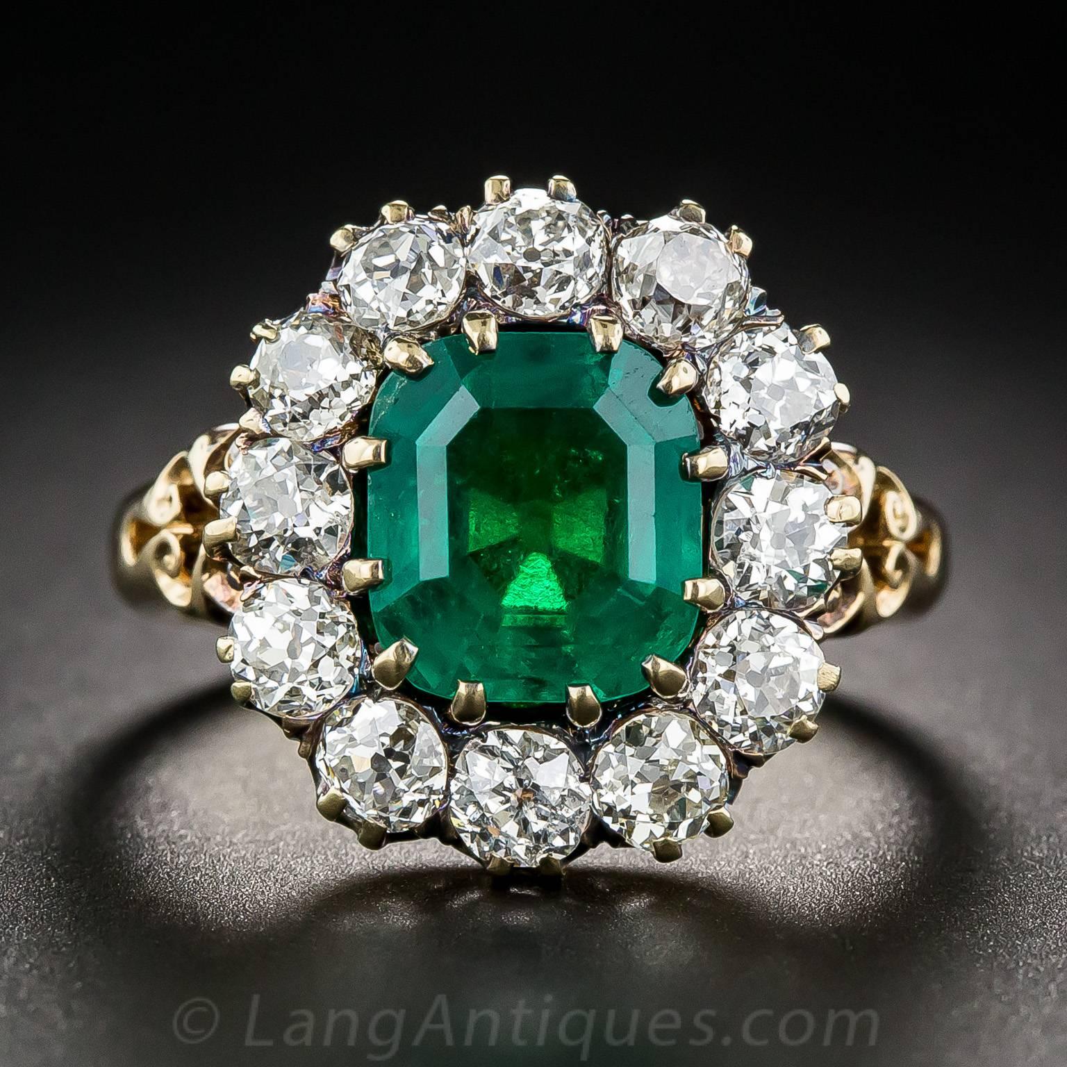 A rich, gorgeous, luscious green Colombian emerald, faceted in a modified emerald-cut shape and weighing 2.75 carats, is framed in a sparkling halo of bright white old European-cut diamonds.  This classic late-Victorian style ring is hand-fabricated