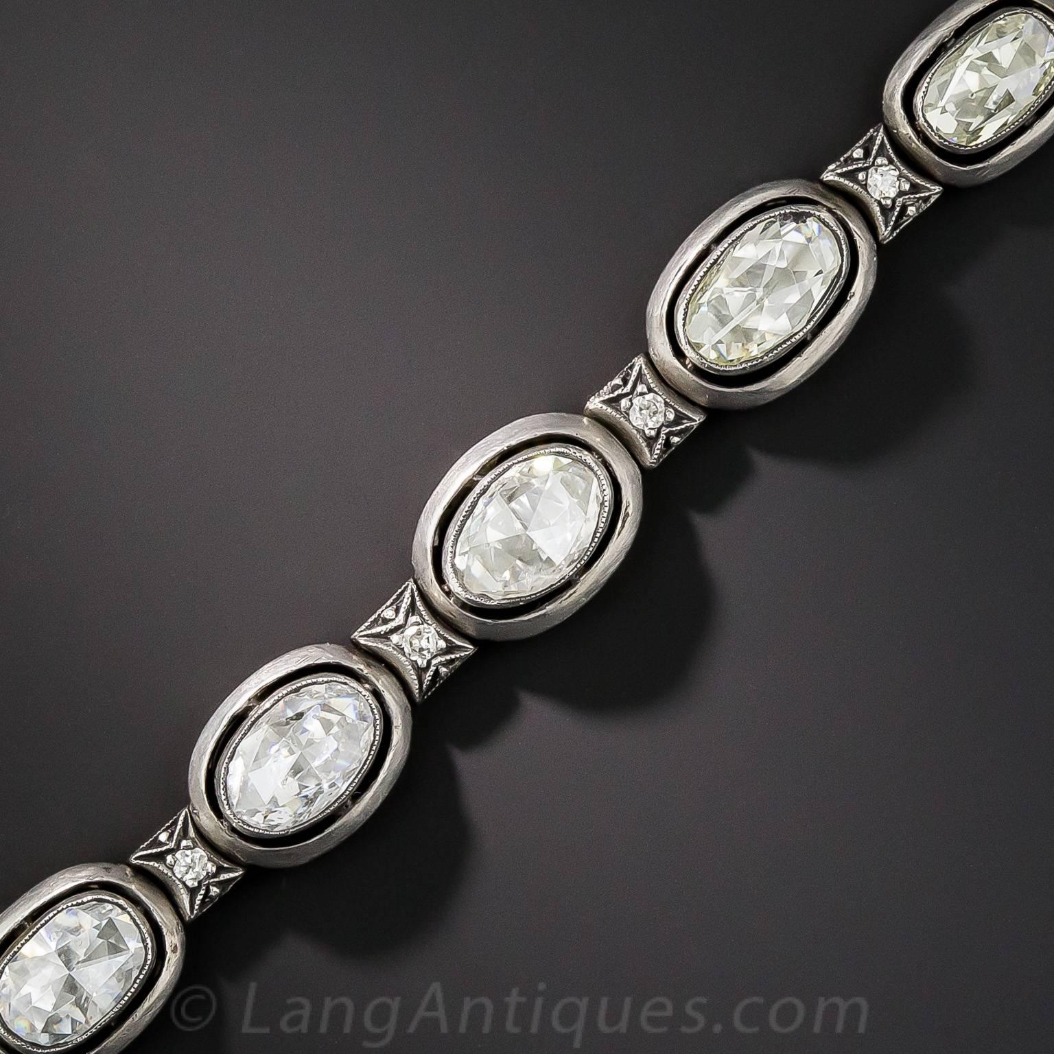 This fabulous bracelet, composed of 12 oval rose-cut diamonds, totaling 10 carats, hails from early twentieth century (1908-1927) Russia. The dozen sparkling white stones are each collet-set in silver and float inside rounded silver frames supported