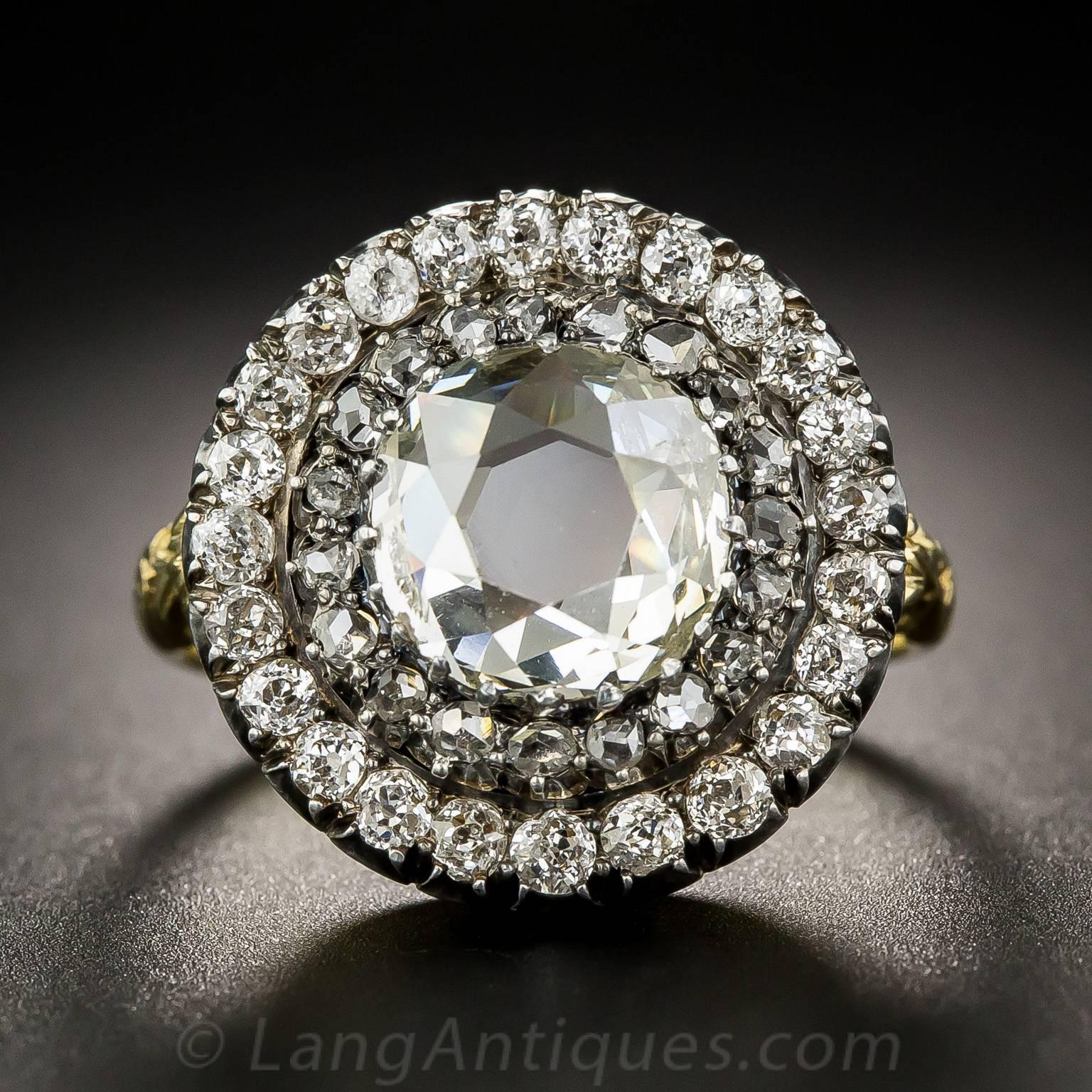 Halfway between a rose-cut and old mine-cut diamond best describes the unique cut of the center diamond in this fabulous and impressive Victorian ultra-sparkler. Although measuring 1.50 carats, the circumference of the stone is equivalent to a
